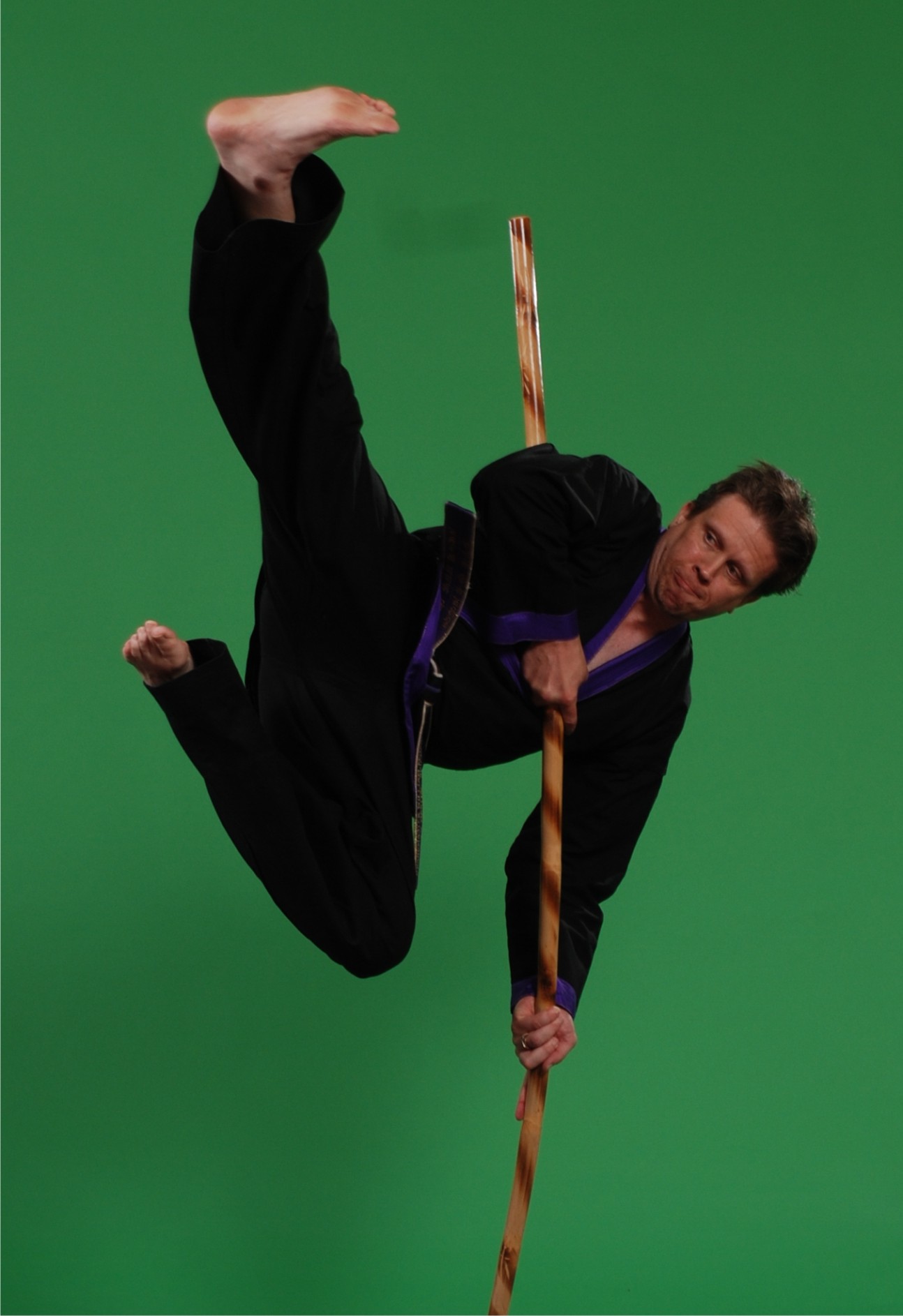 Martial art strike while balancing on a staff.