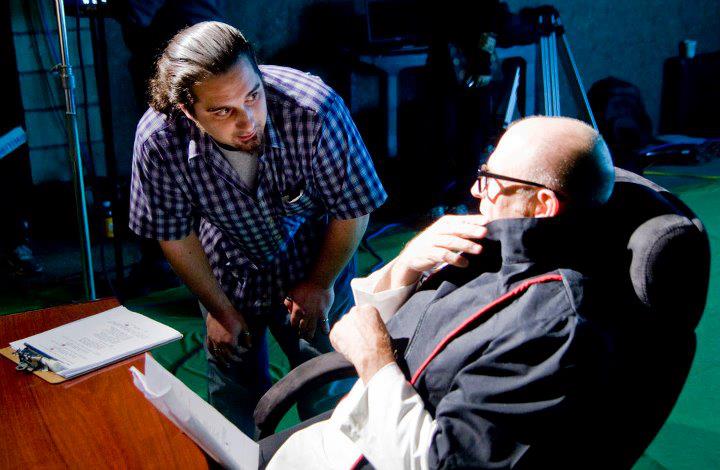 On set of Sensory Perception. Alessandro Signore directing Corbin Bernsen in futuristic classroom scene.