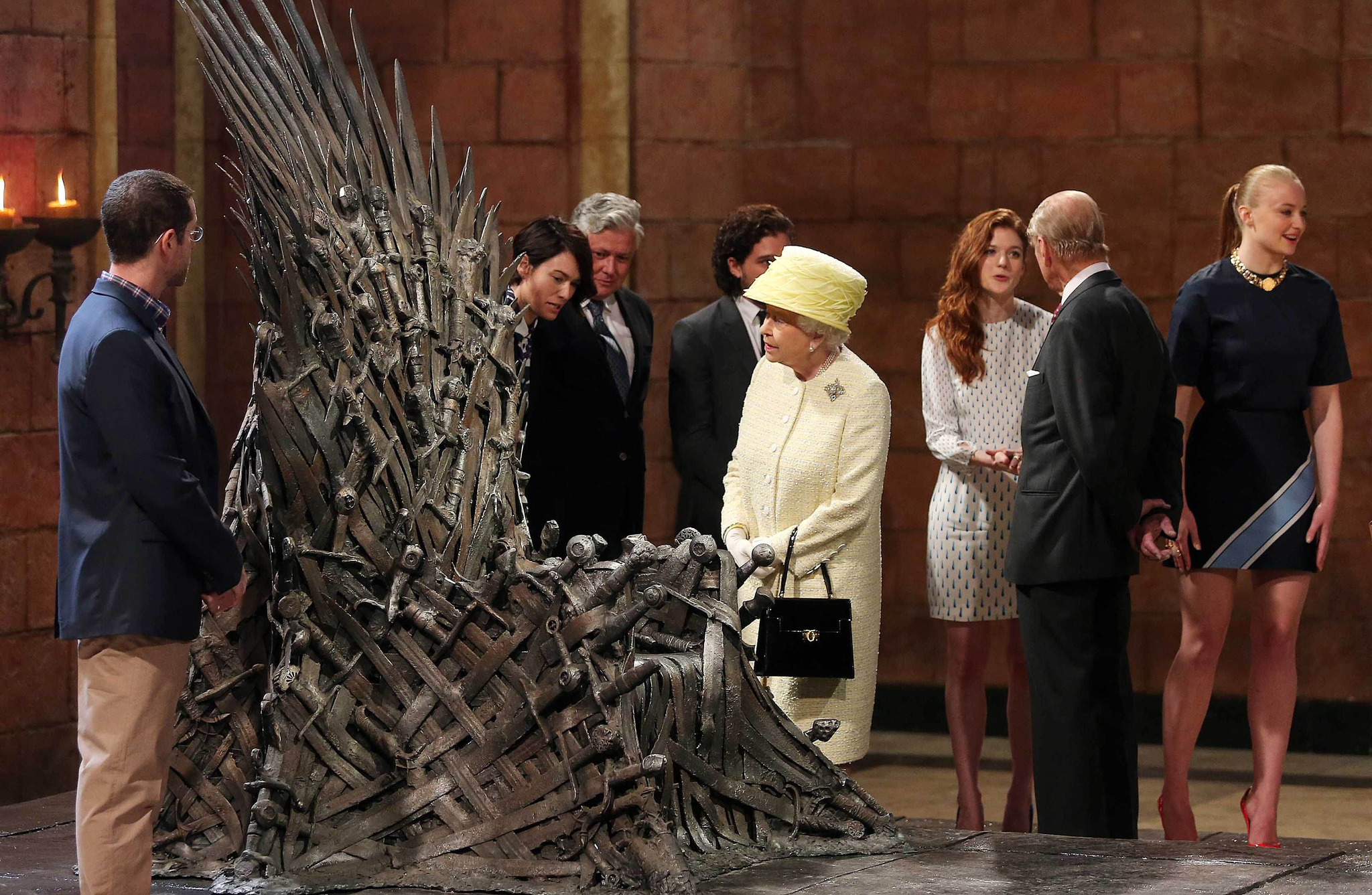 Queen Elizabeth II meets cast members of the HBO TV series 'Game of Thrones' Lena Headey and Conleth Hill while Prince Philip, Duke of Edinburgh shakes hands with Rose Leslie as they views some of the props including the Iron Throne on set in Belfast's Titanic Quarter on June 24, 2014 in Belfast, Northern Ireland. The Royal party are visiting Northern Ireland for three days.