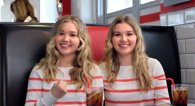 Still of Cailin Loesch (left) and sister Hannah Loesch in new Papa John's TV commercial