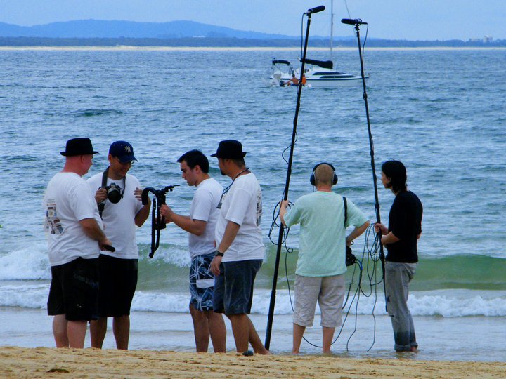 Crew on the beach preparing for a scene in Just like U