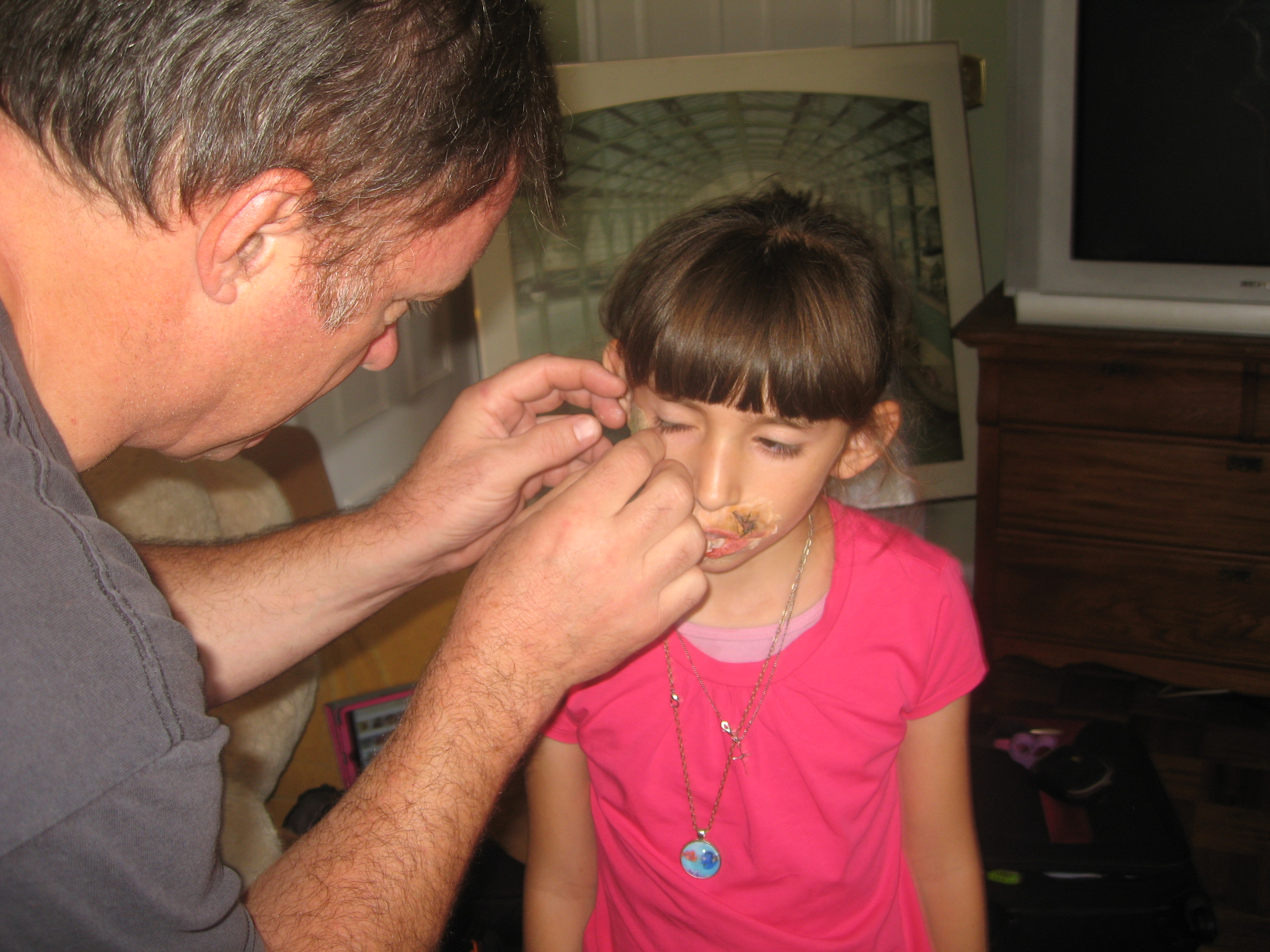 Rick L. Baker applying special effects makeup to Natalie Miranda on the set of 