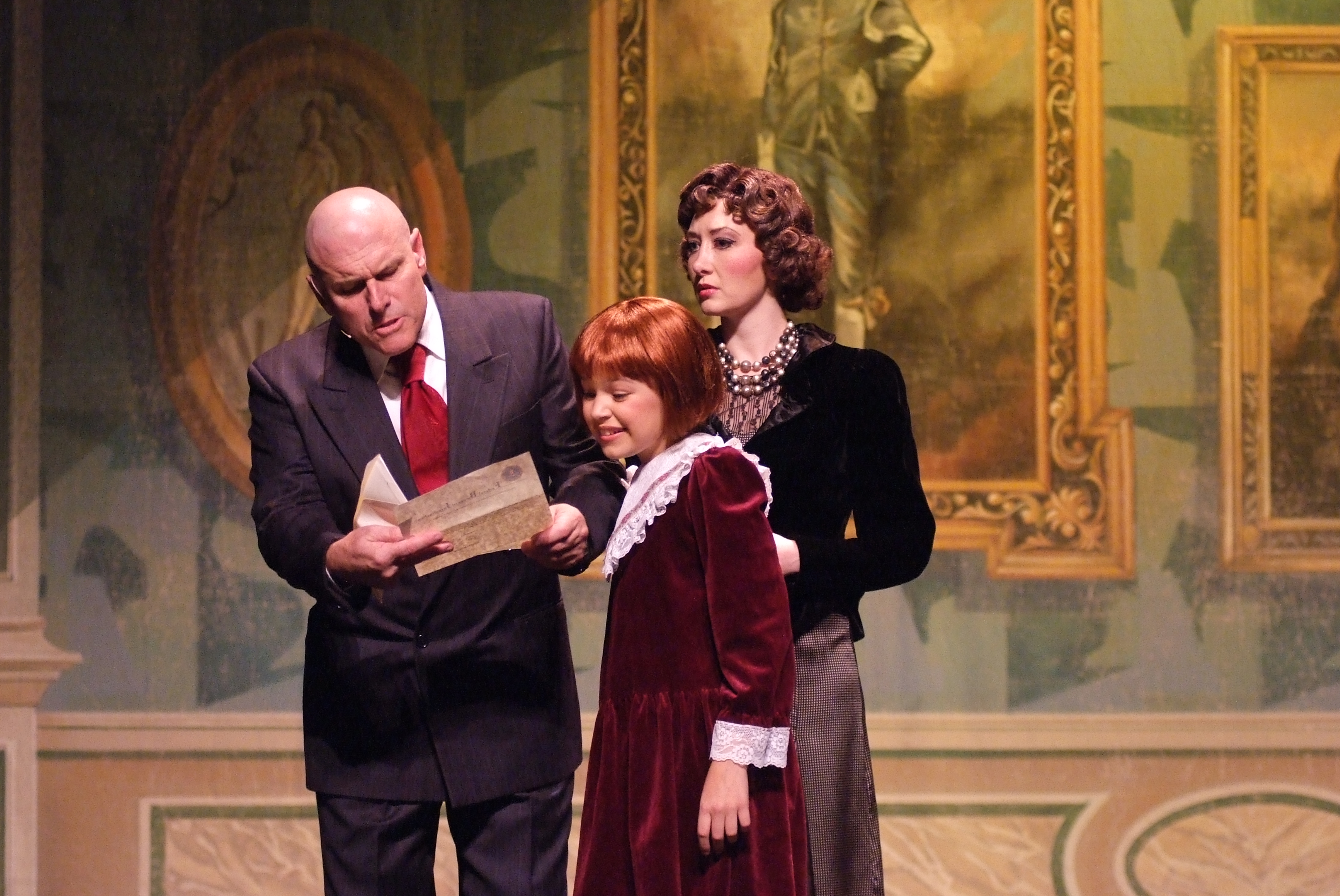 Warbucks (Norman Large), Annie (Quinn Martin), and Grace Farrell (Christanna Rowader) in the musical Annie