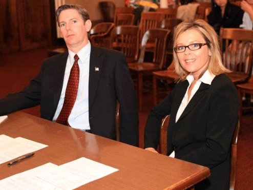 Still image of Jodie Shultz and T. Arnold as District Attorney and Assistant District Attorney on the set of The Alibi.
