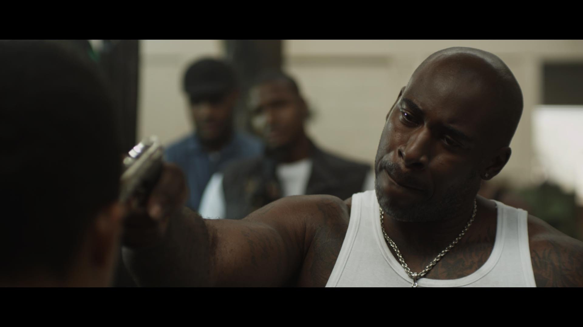 Benzart (Fredi 'Kruga' Nwaka) points a gun at young Cosmo (Miles Wilson) in Callum Andrew Johnston's The Forbidden Note.