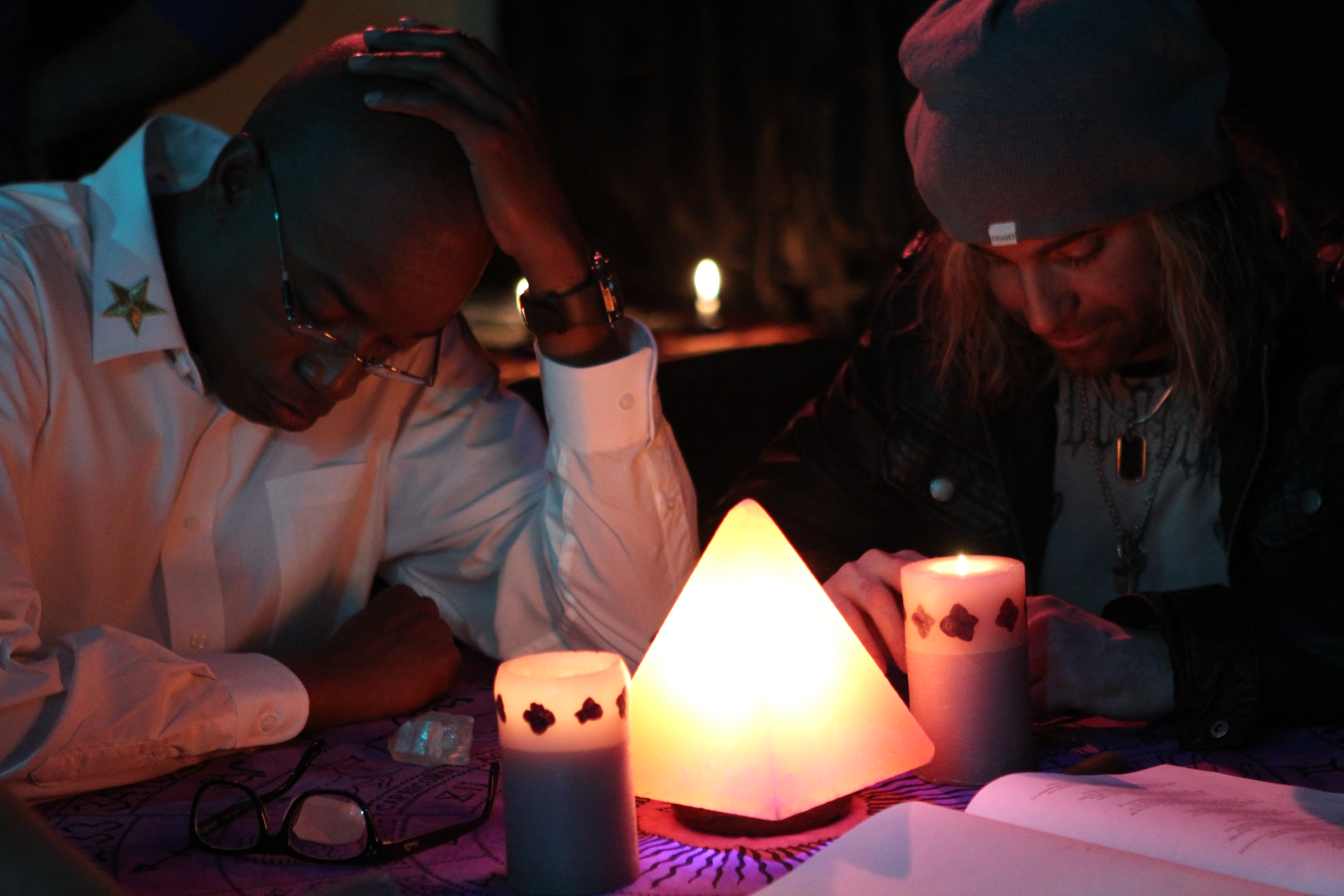 actor Antwoine Steele and actor Bryan David at the seance table in House Of Forbidden Secrets
