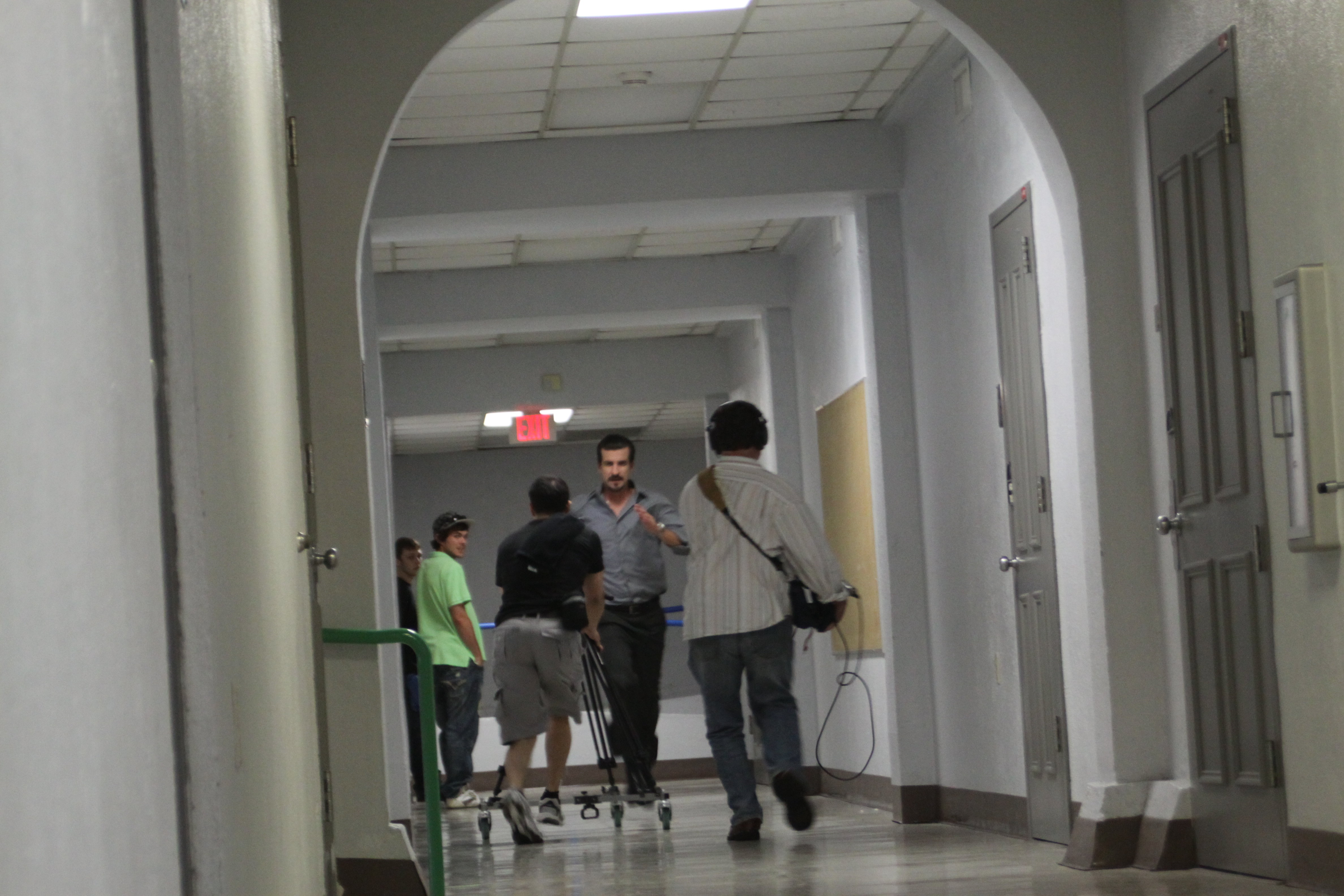 Martin Lemaire and Michael Scott Andrews run backwards as Michael Dunsworth runs down the hallway on the set of Hide. Liam A. Miller and Daniel Curtis look on.