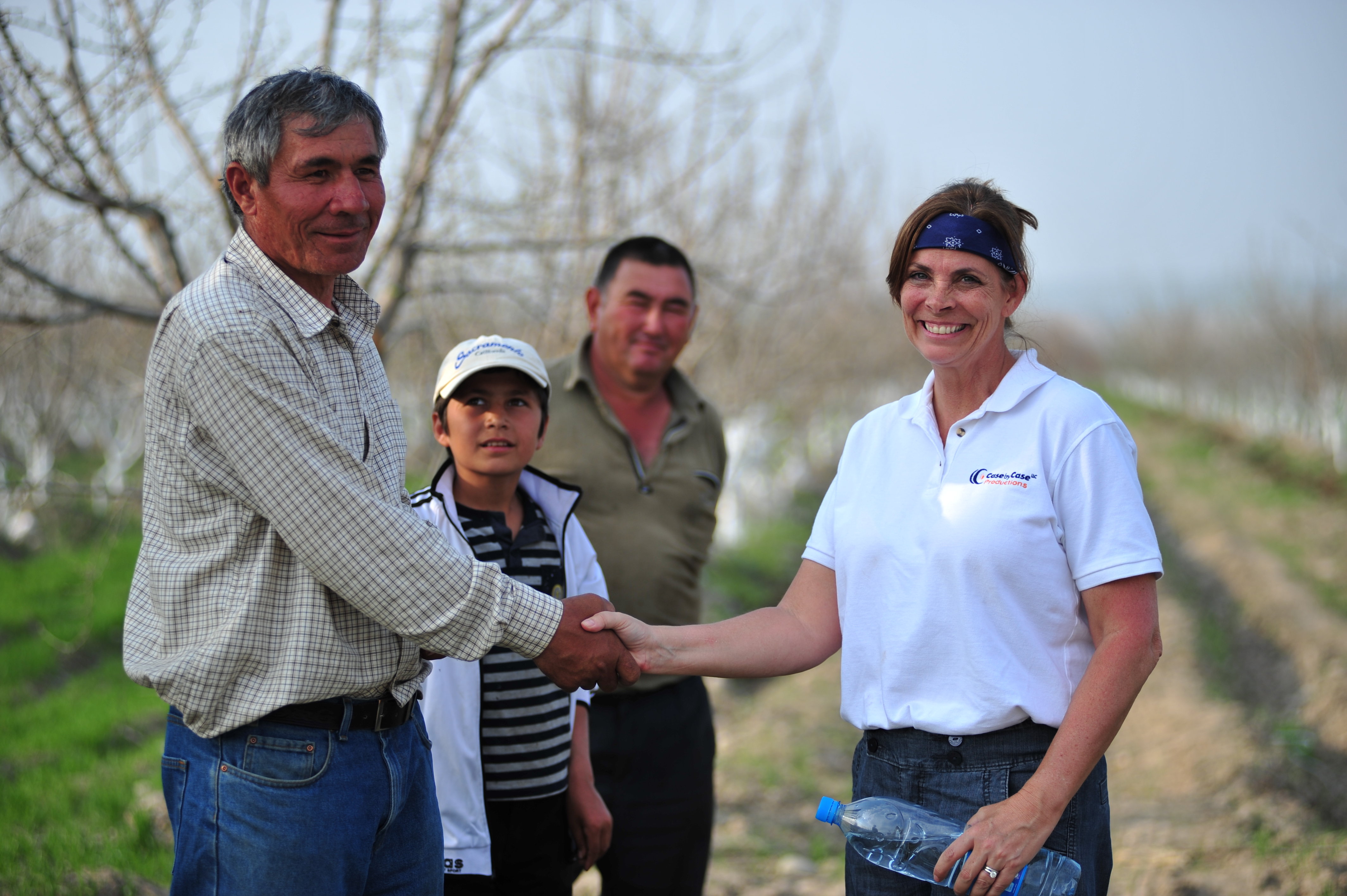 Associate Producer/Production Manager Nancy Singleton Case meets with Uzbek farmer and son in orchard outside Fargona, Uzbekistan