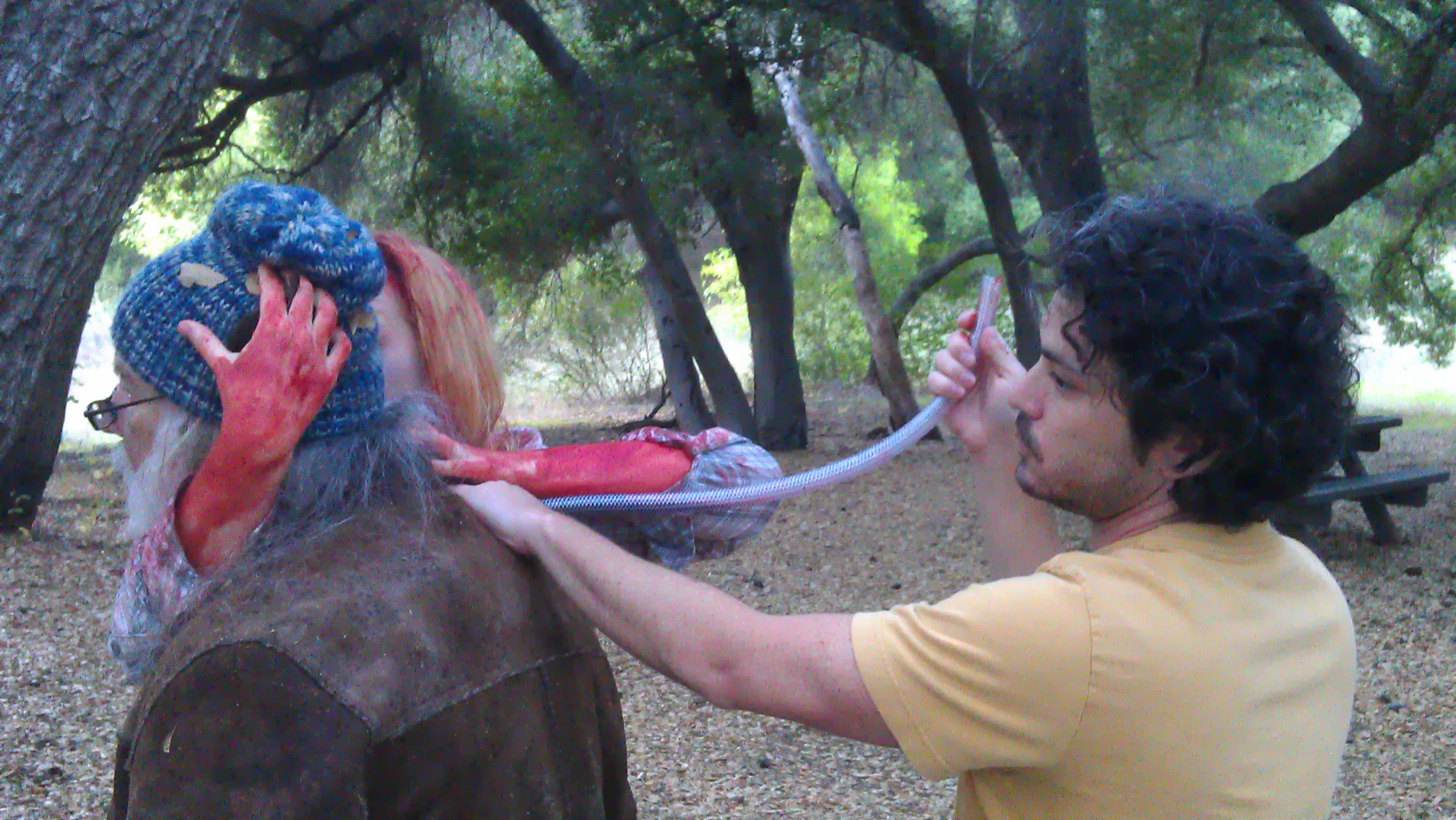 Evan blows blood out a tube for the homeless guy zombie attack shot for 'Blood Rush.'