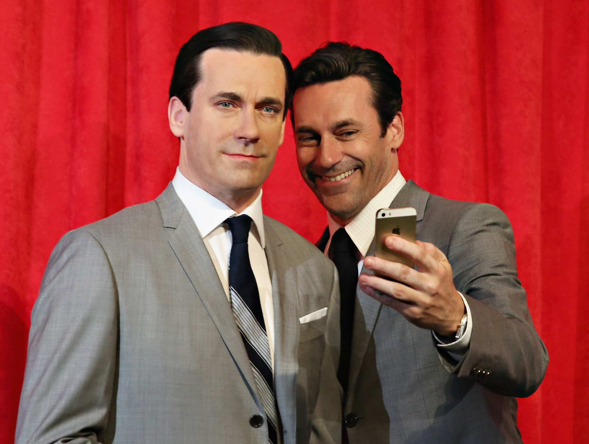 Actor Jon Hamm takes a selfie as he unveils Don Draper's wax figure during Mad Men's Final Season at Madame Tussauds New York on May 9, 2014 in New York City.