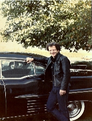 Joey posing next to one of his classic cars.