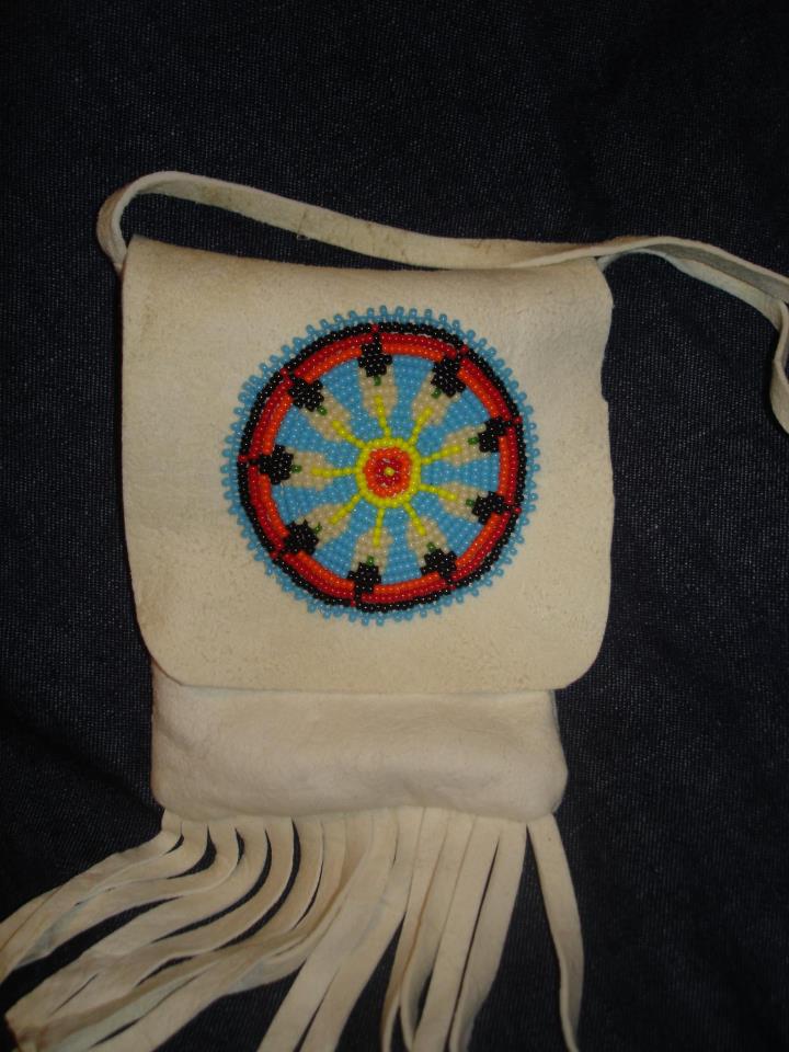 Deerskin beaded pouch - I first brain tanned the deer hide then used the hide to make this pouch and added beads. The threads do not go all the way thru the hide so they do not show on back.