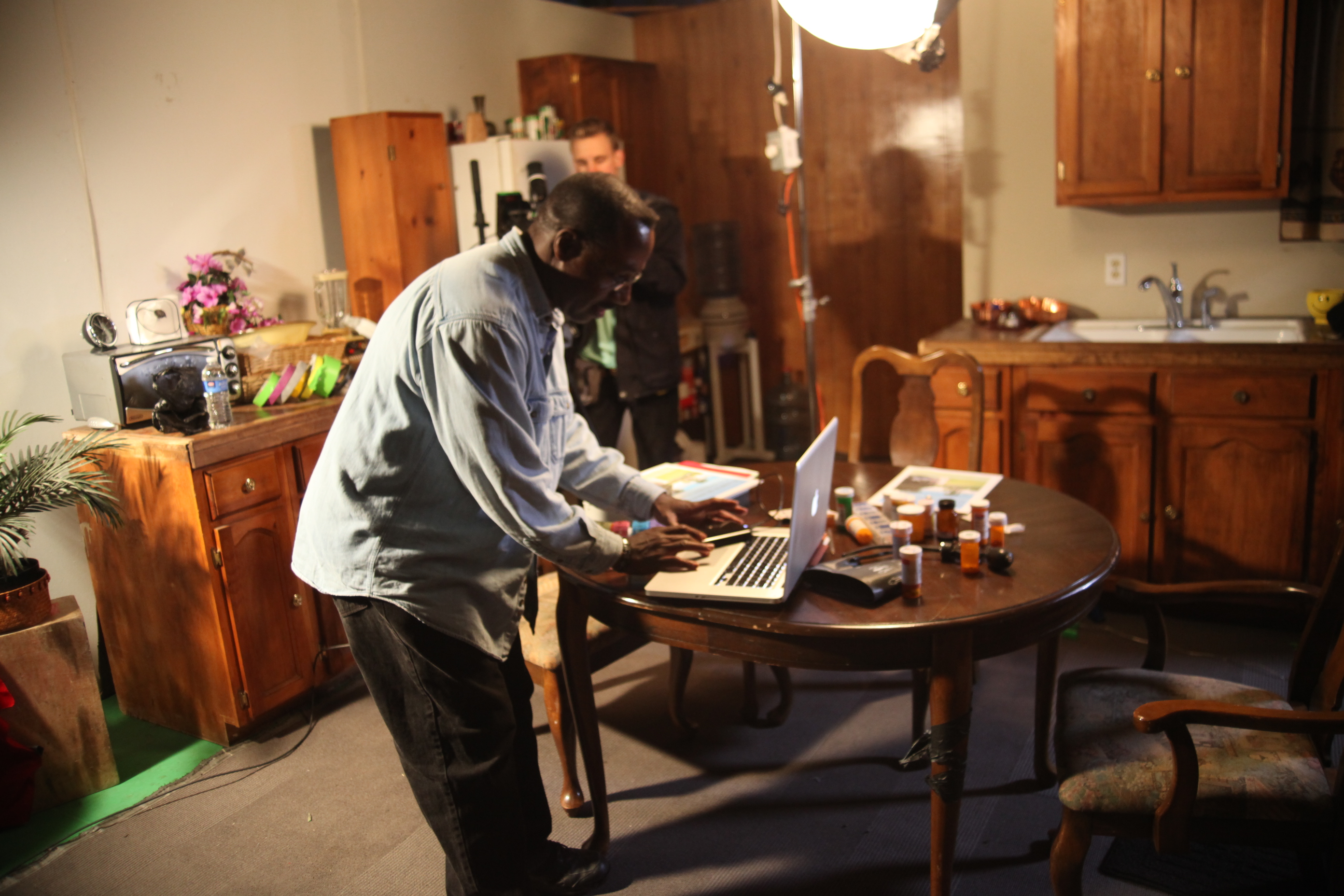 Director Bruce B. Gordon working out production design and prop issues on the computer, while camera assistant James Souter and the 