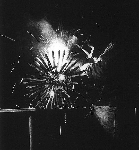 Sculptor Bruce Gray welding a sculpture.