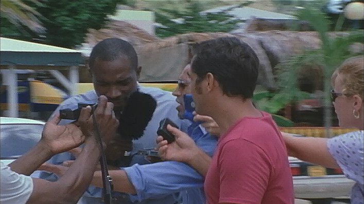 Mehmet Mizrap surrounded by reporters in the French West Indies in 