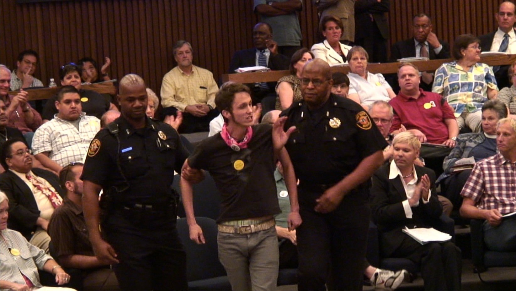 Queer LiberAction founder Blake Wilkinson escorted out of Fort Worth City Council Chambers after heated exchange with Mayor Mike Moncrief. From documentary 