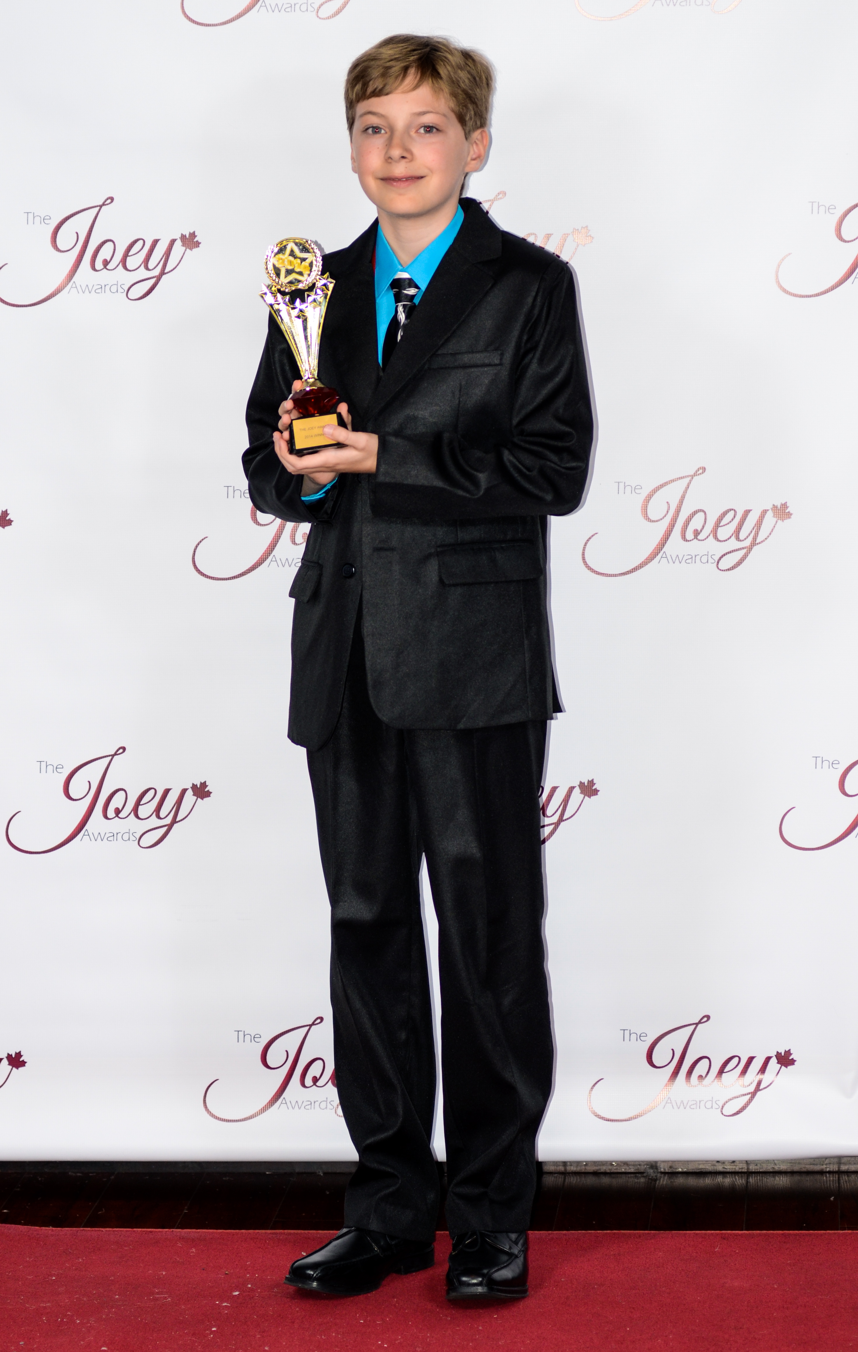 Alex with his 2014 Joey Award for his role as the voice of Zuma in PAW Patrol
