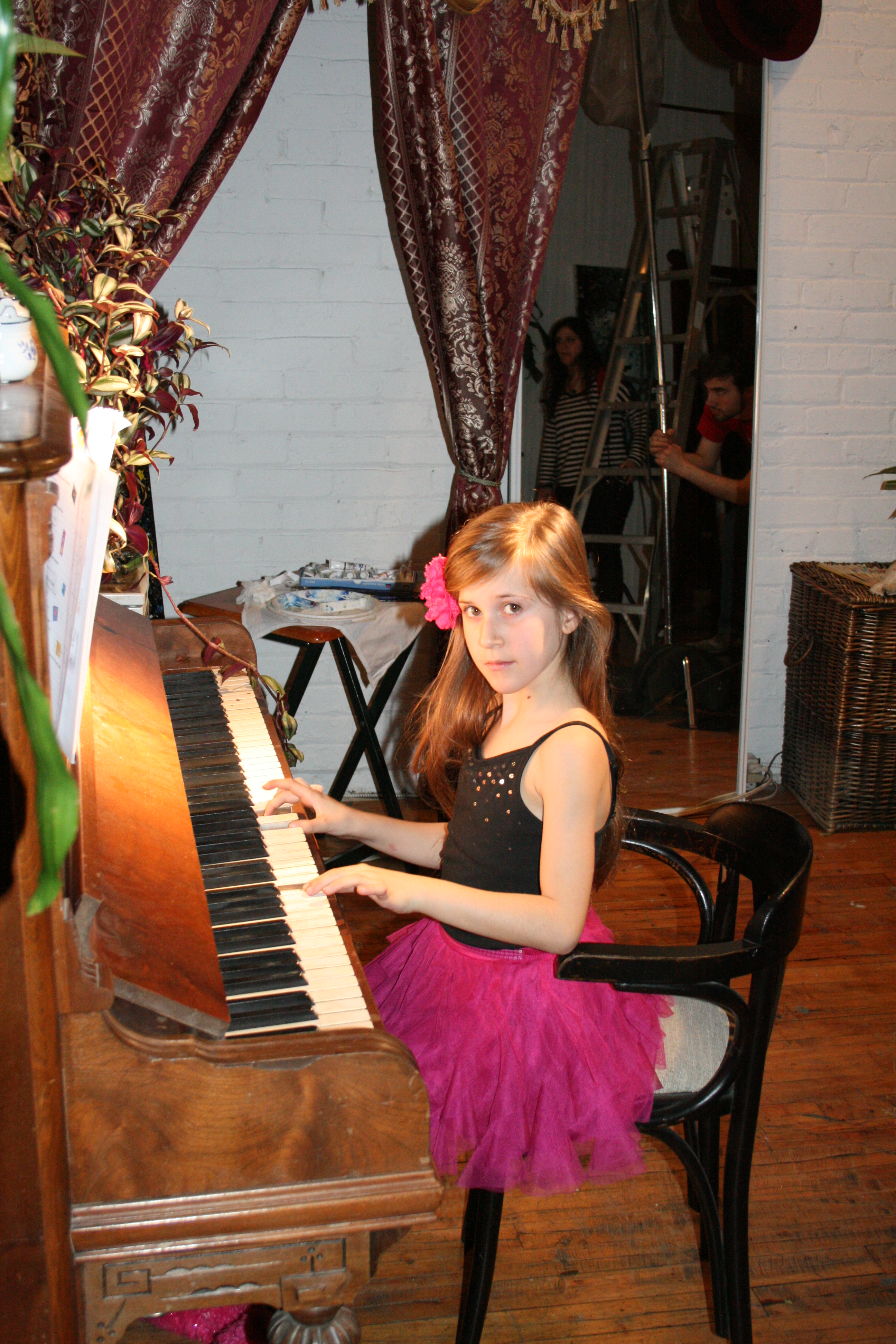 Gloria posing with the piano on the set of ABOUT THE AUTHOR.