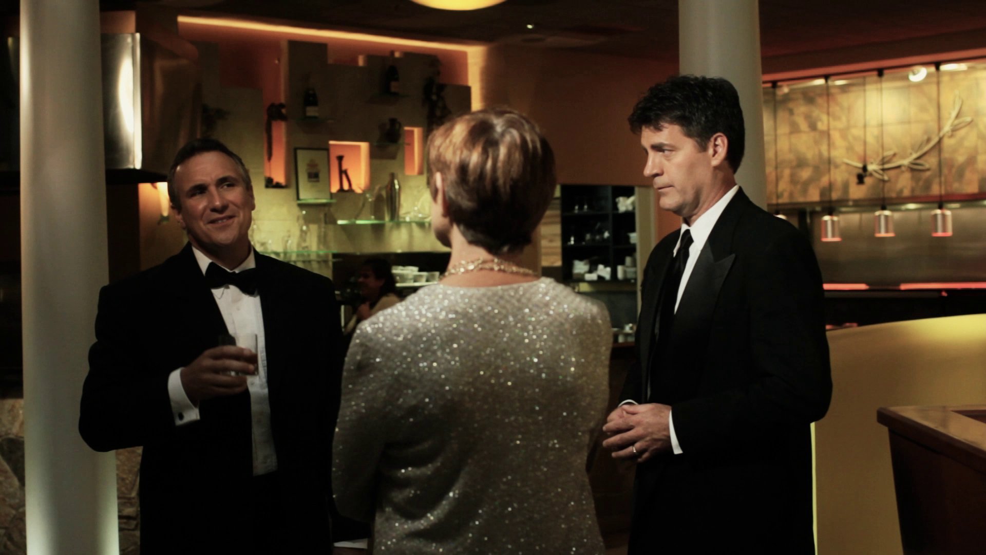 Moments before Henri Miller's arrest, John Darrow, Miller's lawyer, offers district attorney Constance Smith a drink at the grand opening of Henri's third restaurant.