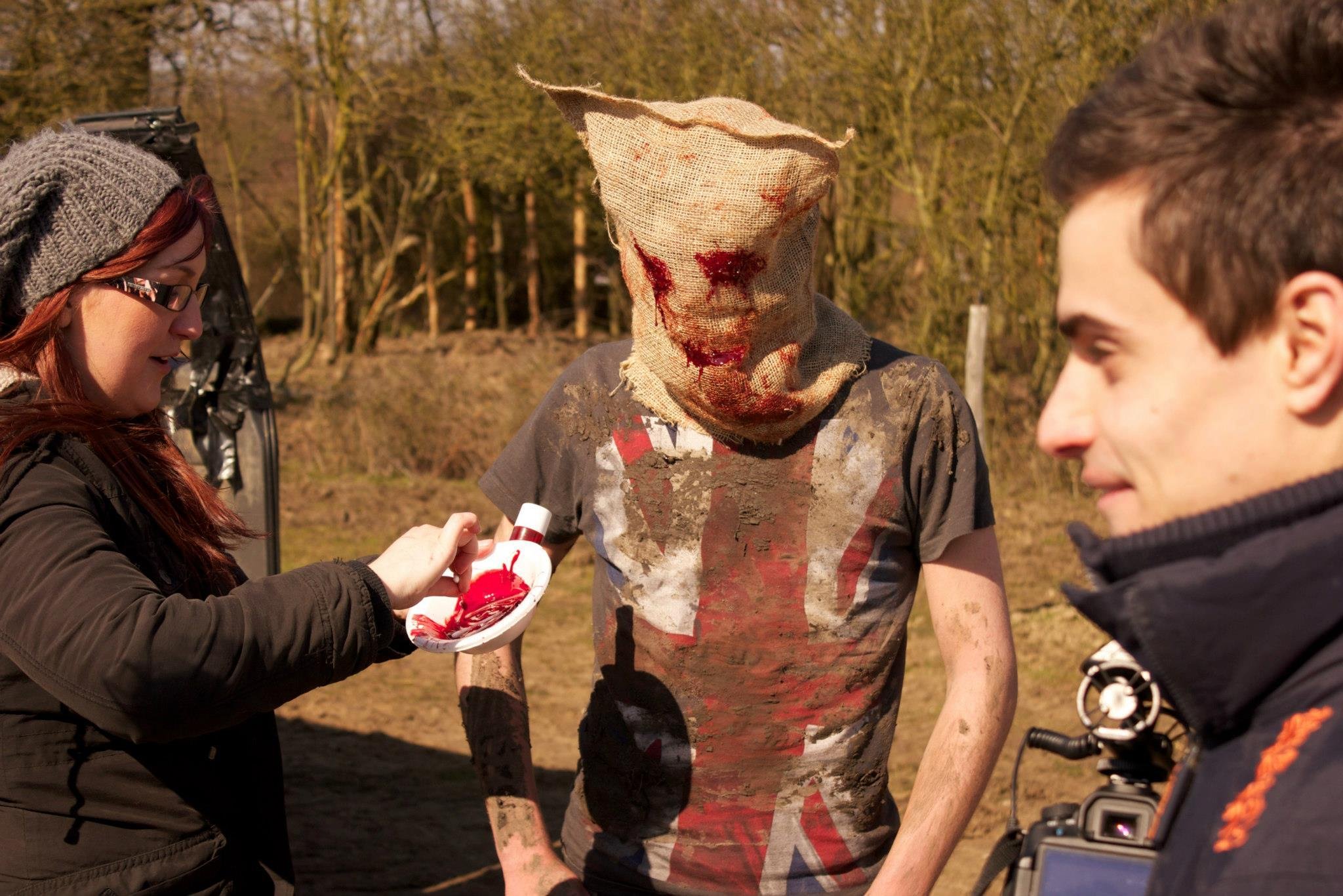 Makeup artist Justine Carter applies finishing touches to actor Liam Ponder with Mark Castro on set of sci fi horror short Blues Skies