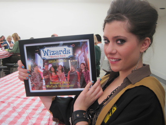 Brittany Rizzo holding her 100th episode of Wizards Of Waverly Place plaque.