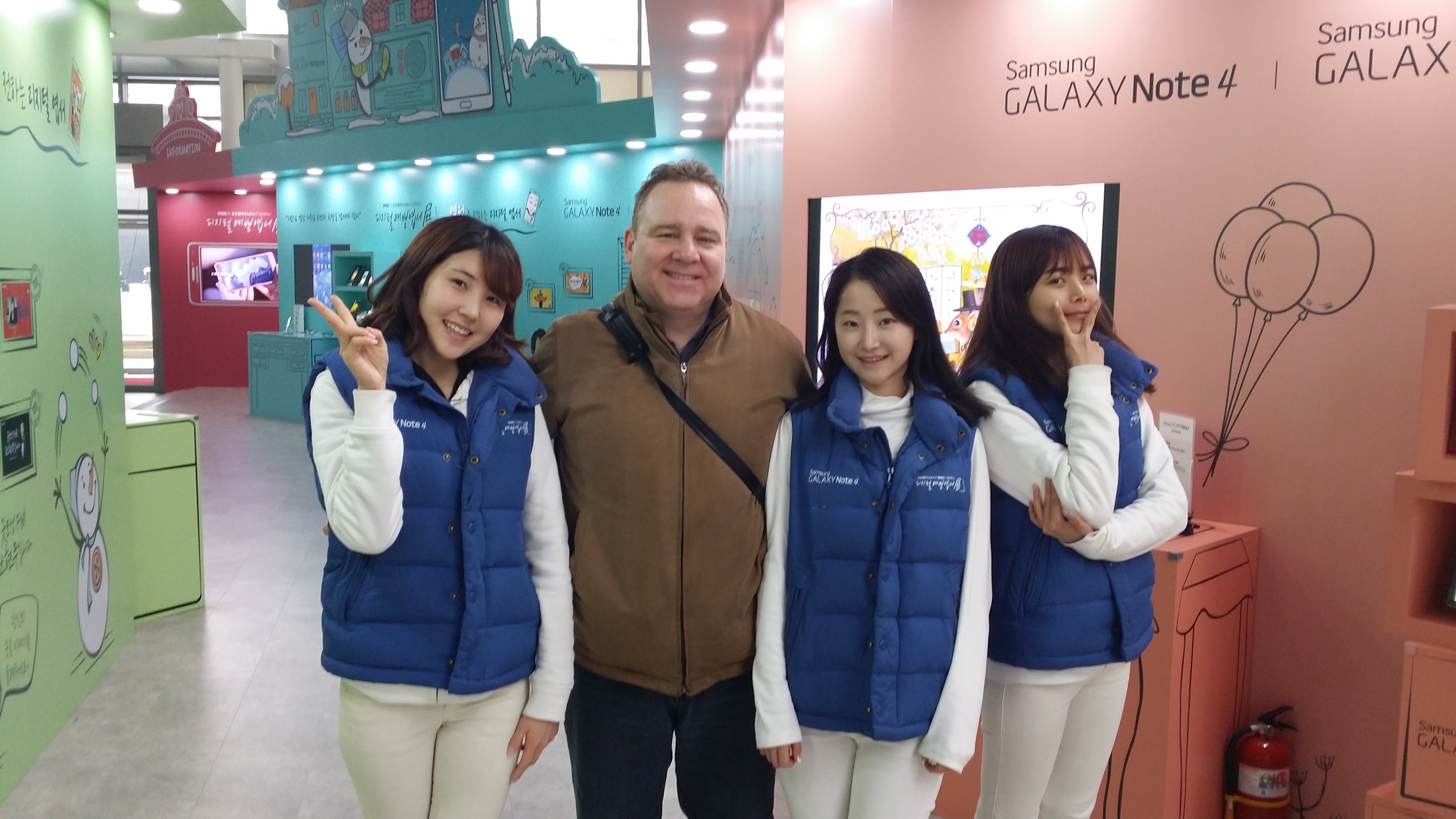 Dean Dawson poses with the spokeswomen of the Samsung Galaxy Note 4.