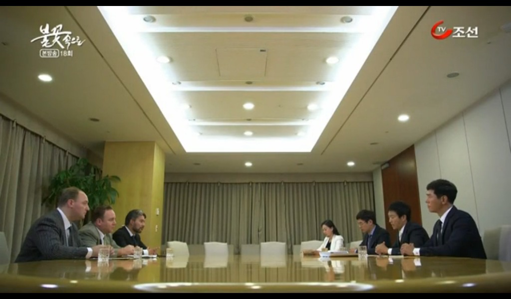 Still of Dean Dawson (center left) as Pres. Hunt playing opposite Soo-jong Choi (center right) as Tae-hyeong Park for Chosun TV's Into the Flames. Based on the life of Tae-joon Park, the founder and chairman of steel maker company POSCO.