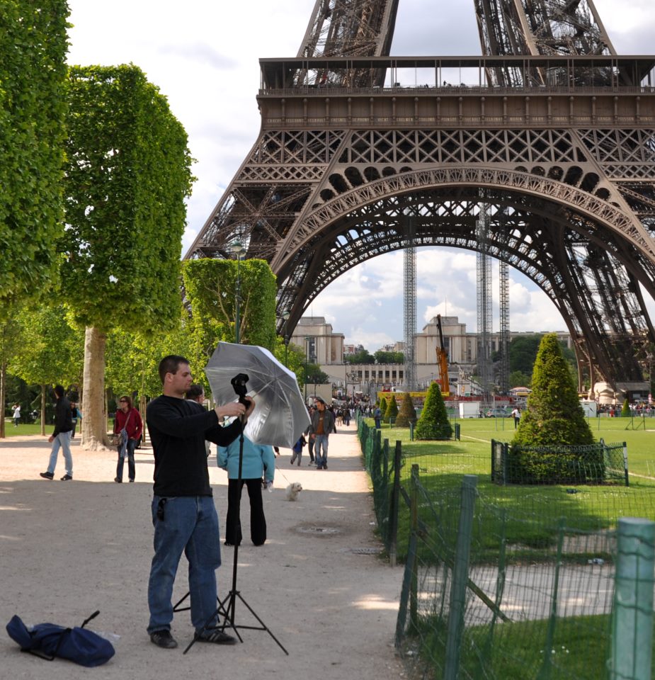 Dan Weecks setting up lights for a stand-up in front of the Eiffel Tower in Paris, FR