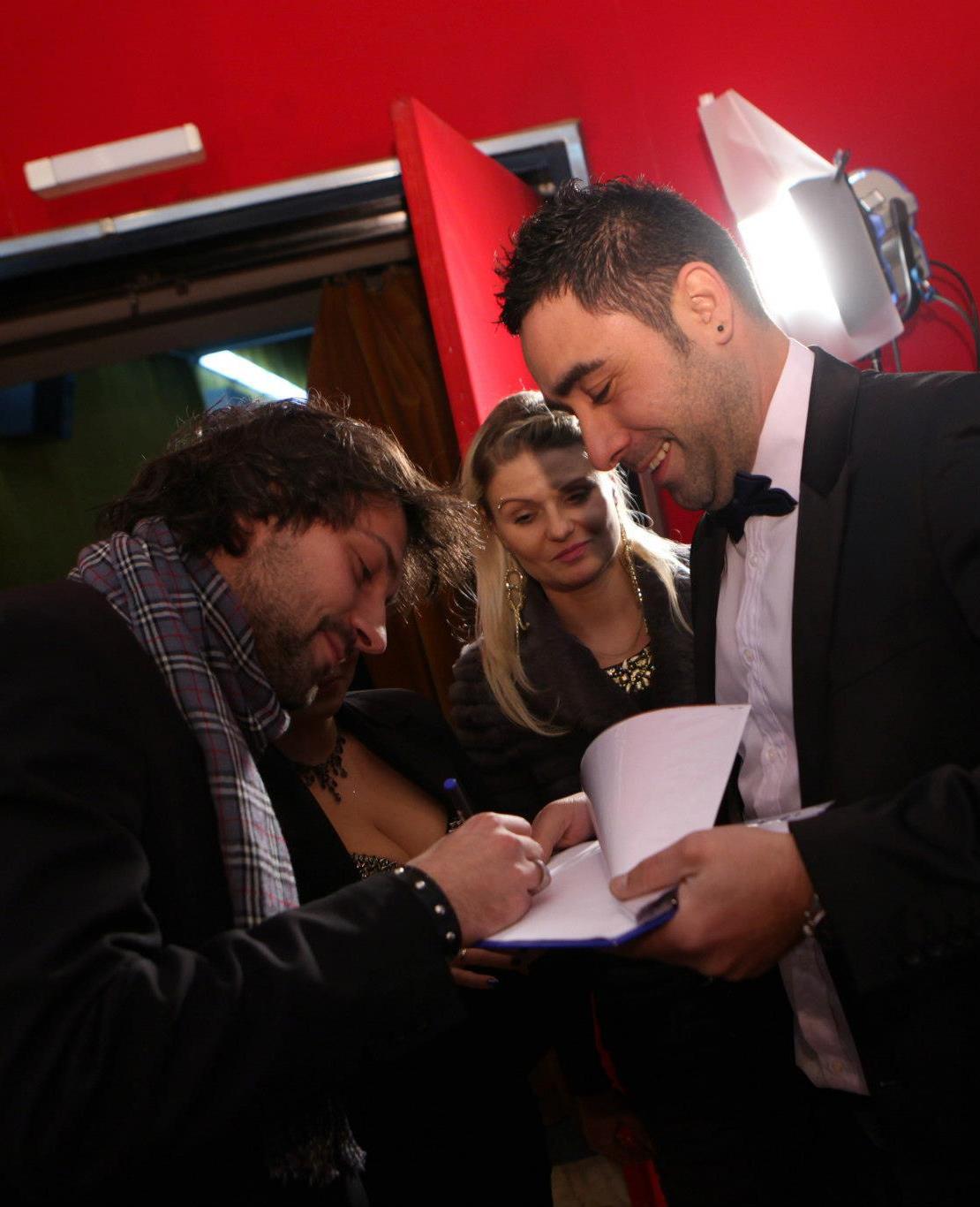Dragos giving an autograph to a fan.