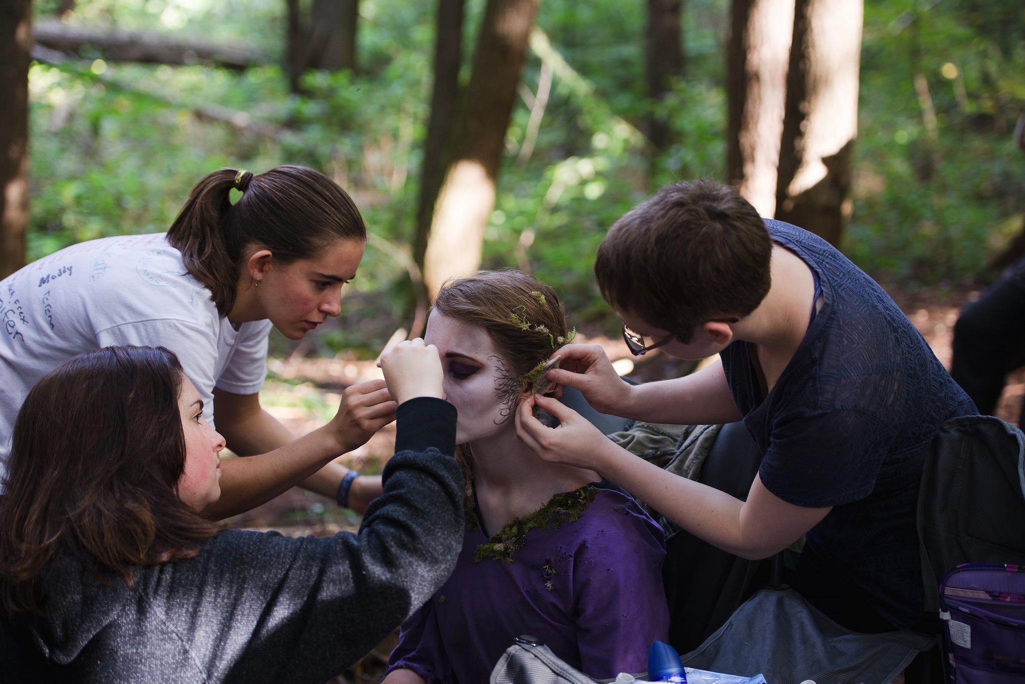 Julia Frangione, Laura Gray, and Morgana McKenzie performing makeup touchups on Rose Donoghue as 