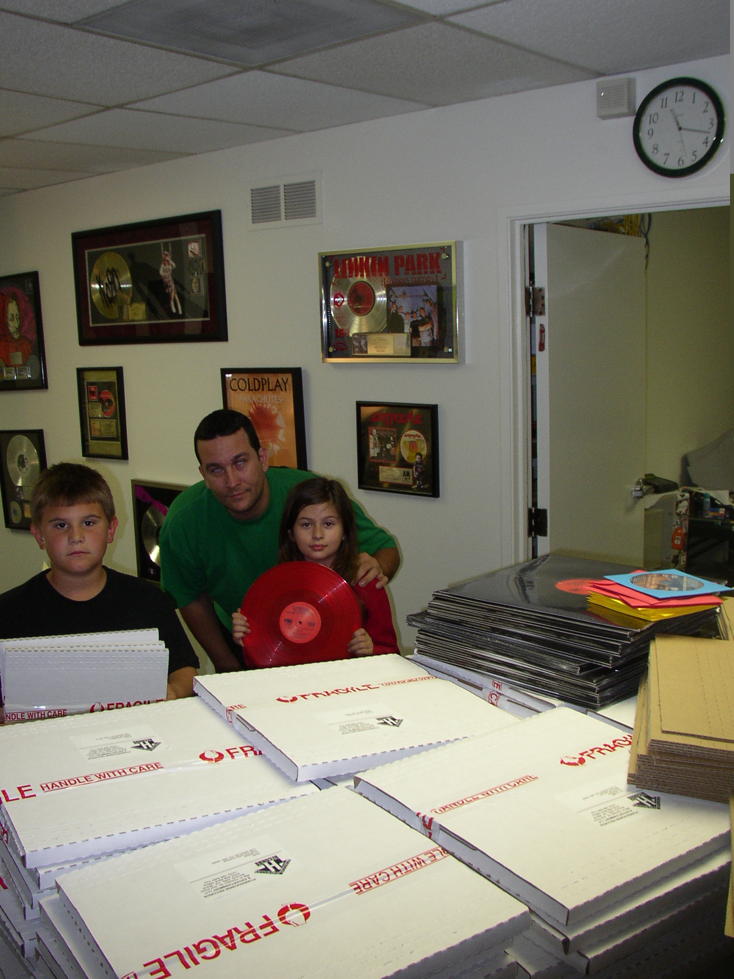 Young Cody Quinn, music manager Rob Quinn, and his daughter Megan in the label's DJ mail room.