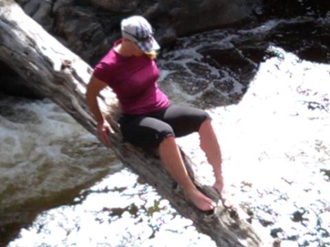 Wild Woman Kellie Nightlinger crosses a raging river on a narrow log