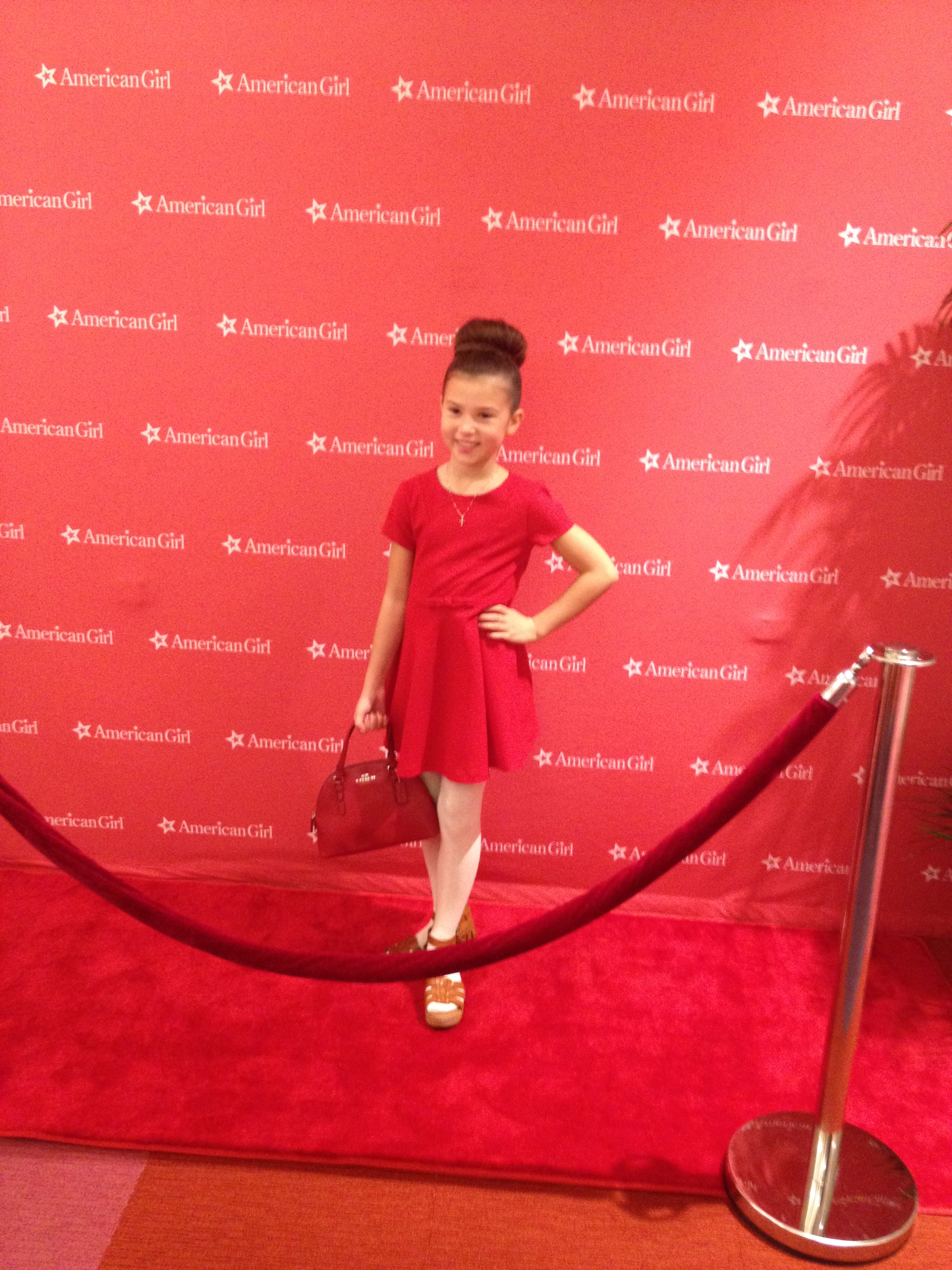 Working the red carpet wearing a Zara dress and a Coach bag.