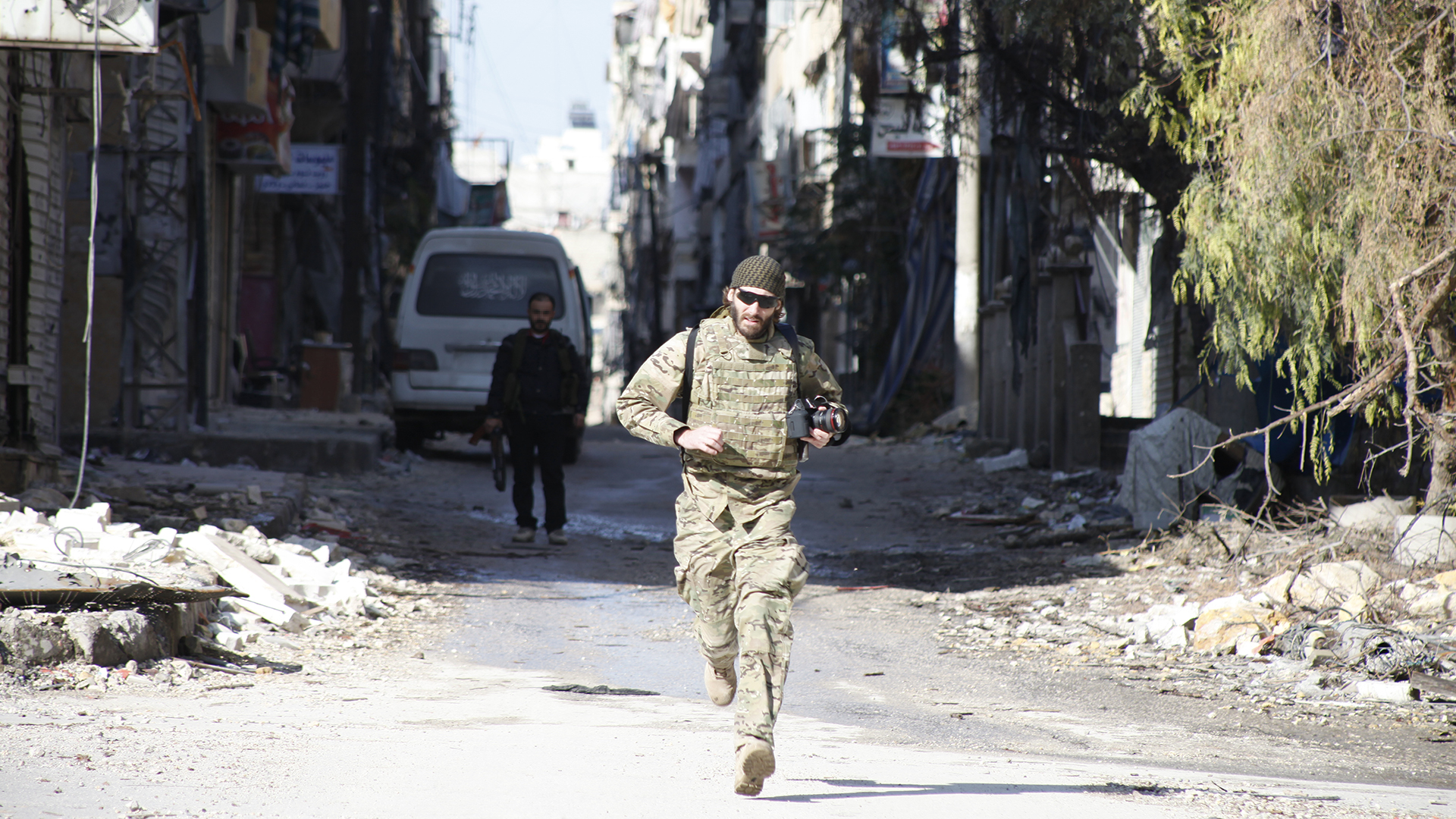 Matthew VanDyke running across a street to avoid snipers in Aleppo, Syria while filming 