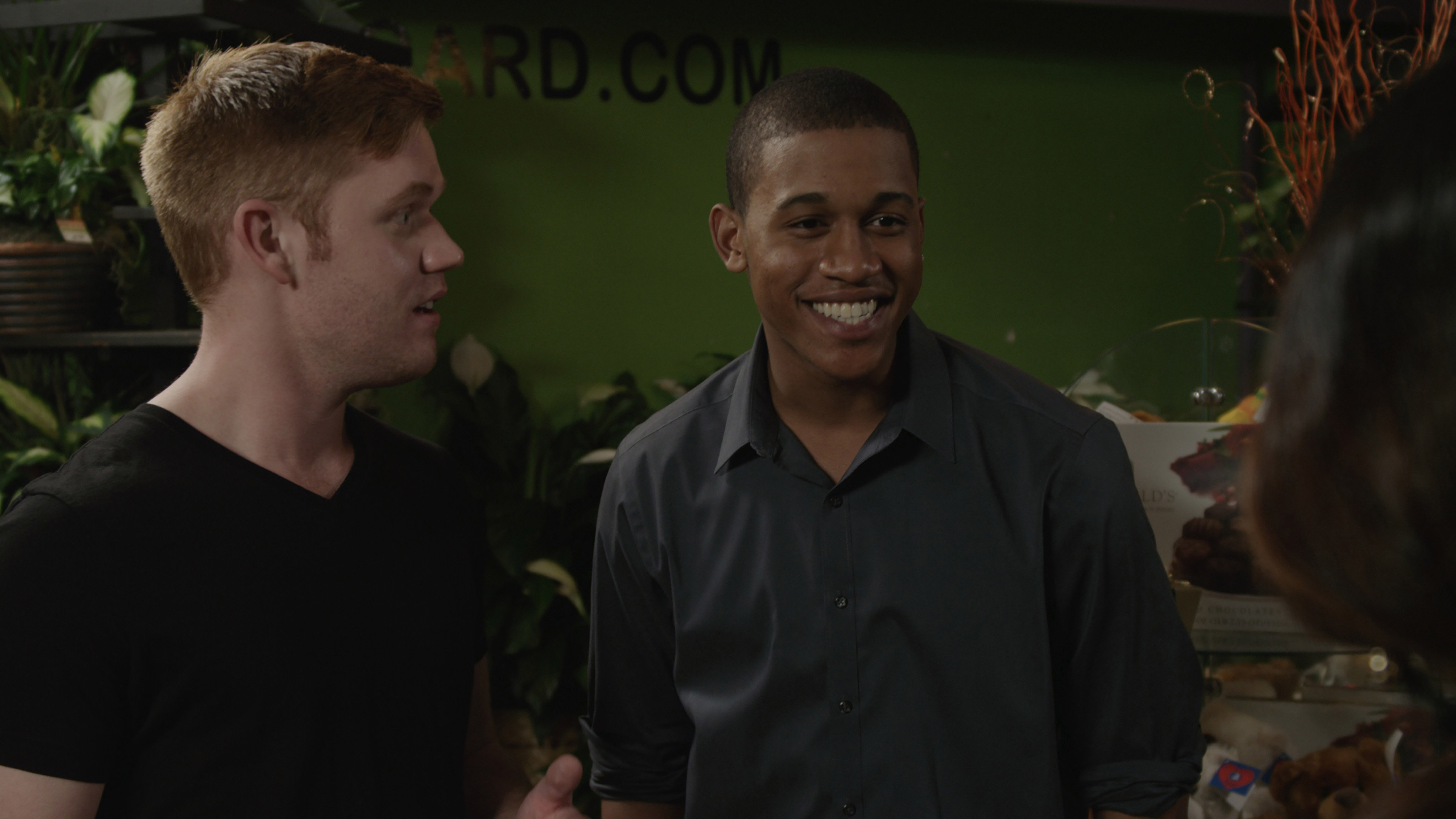 From left to right: James Poole (Paddy), Lance Lemon (Chuck). 'Chuck' facilitates an initial meeting in the flower shop scene.