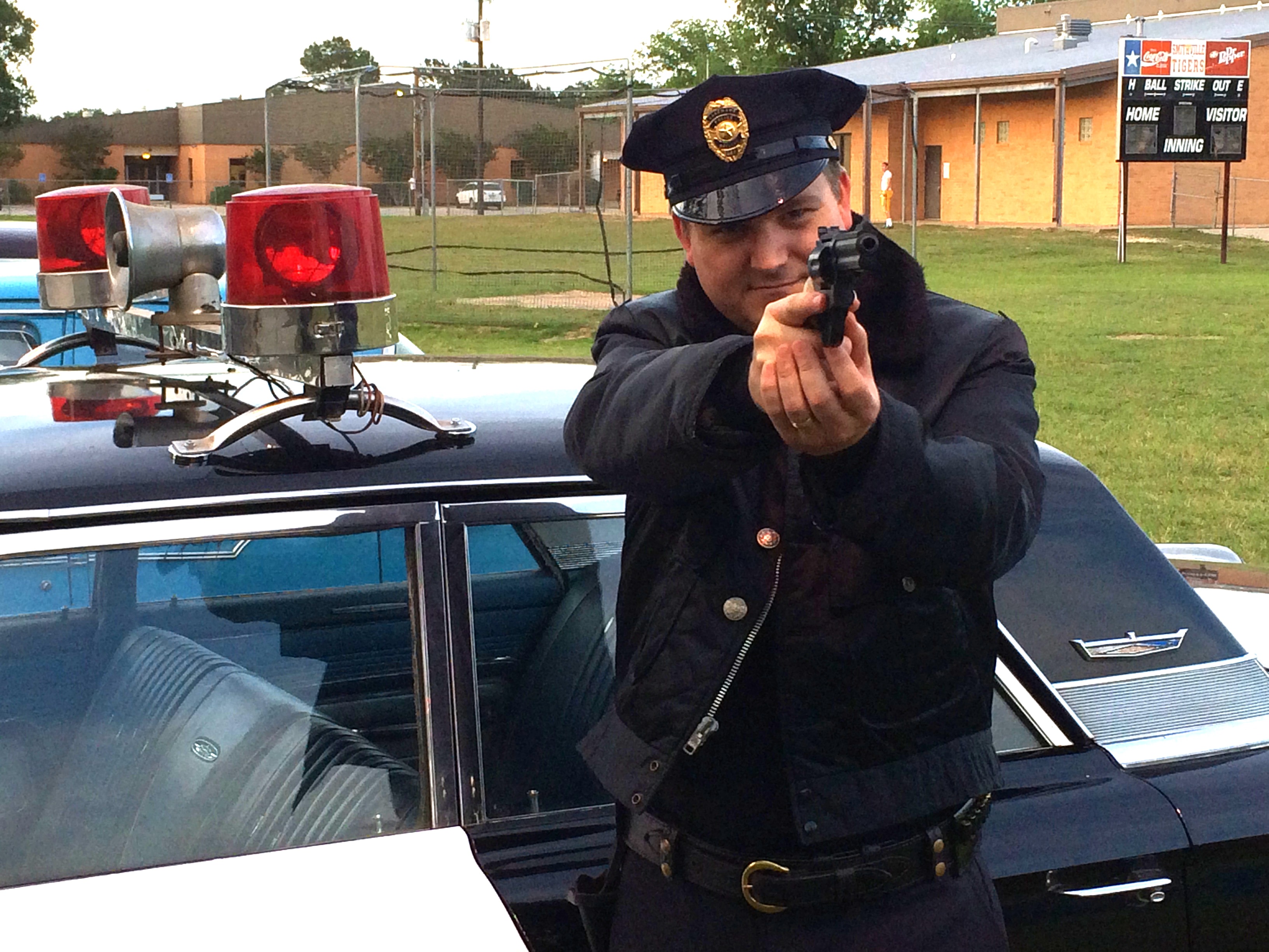 Ready for action. On set as a 60's cop