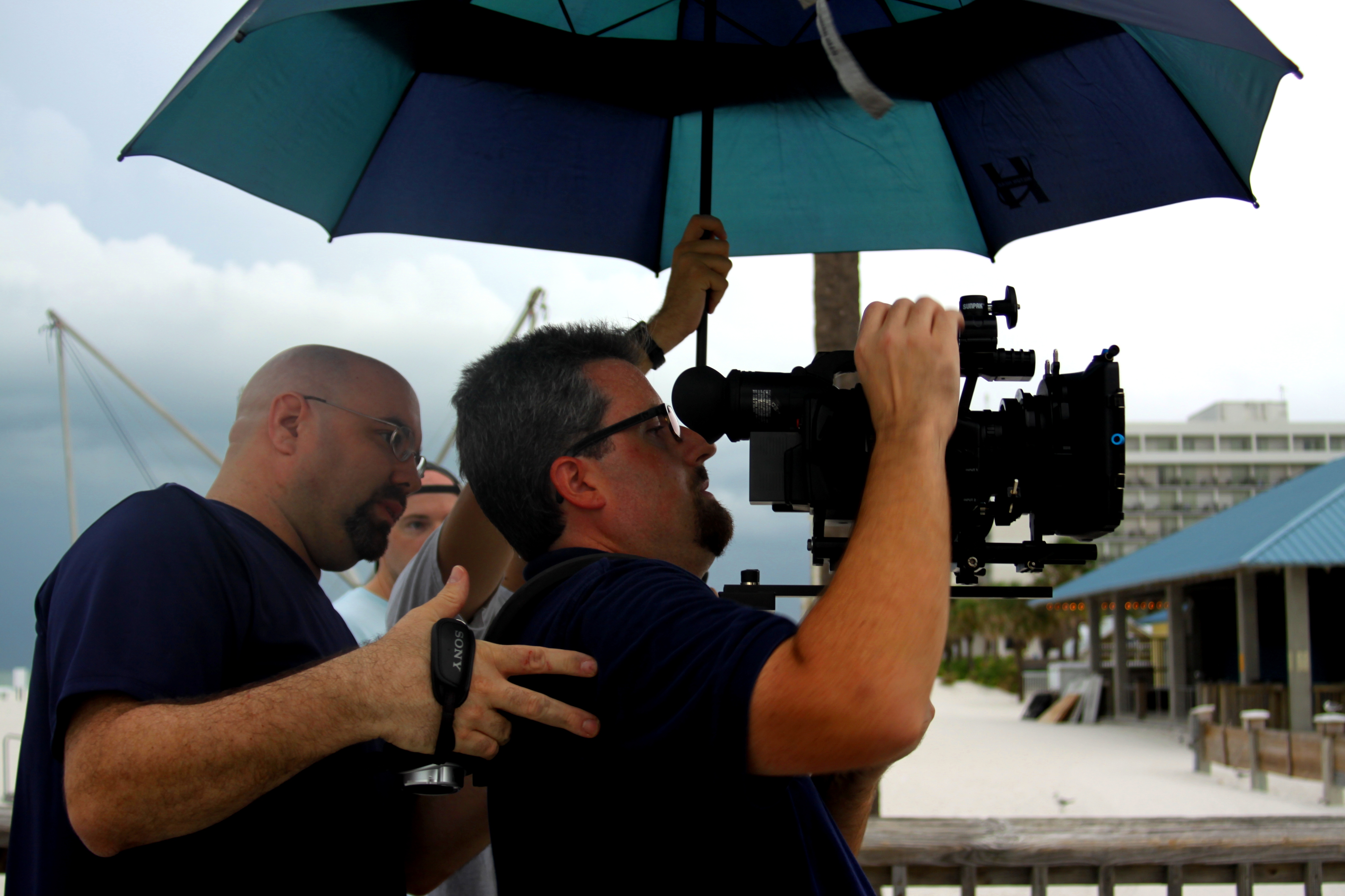 Director Donald E. Reynolds watches through the camera as it rains on an early morning 