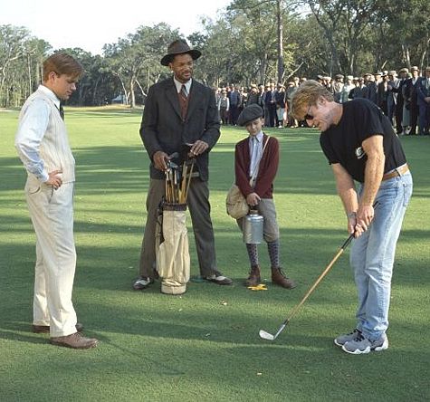 Director Robert Redford demonstrates a golf swing for his stars