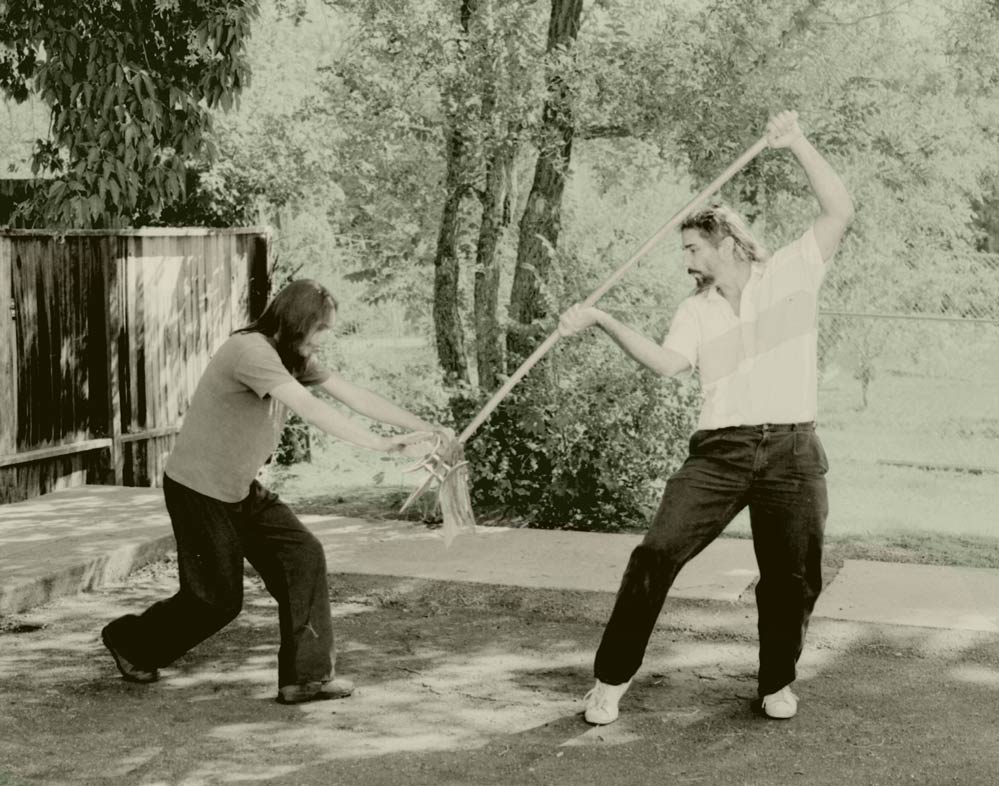 In our slow-motion battle, we both end up in a defensive position. I'm proud of all the slashes and sword cuts in my spears, staffs, and 3-sectionals. Even my swords look like serrated steak knives from my students and children's weapon sparri