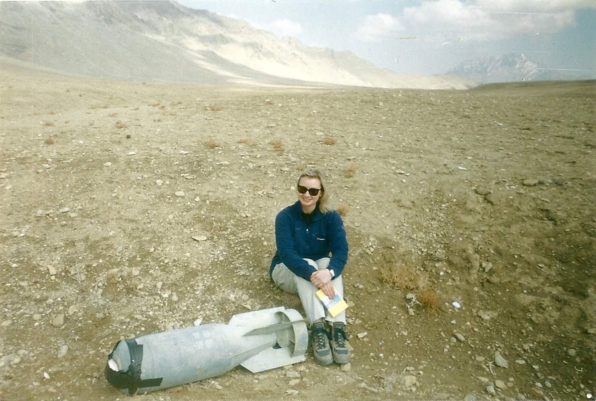 War Reporter Alex Quade in Afghanistan 2002. Sitting next to unexploded ordnance.