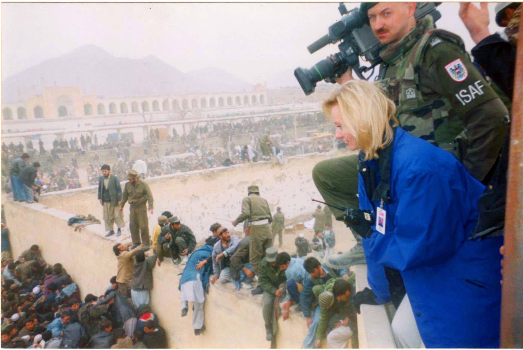 War Reporter Alex Quade for CNN in Kabul, Afghanistan during riot. Quade and an ISAF soldier found high ground for safety for Quade to report, while maintaining radio contact with CNN crew in other location.