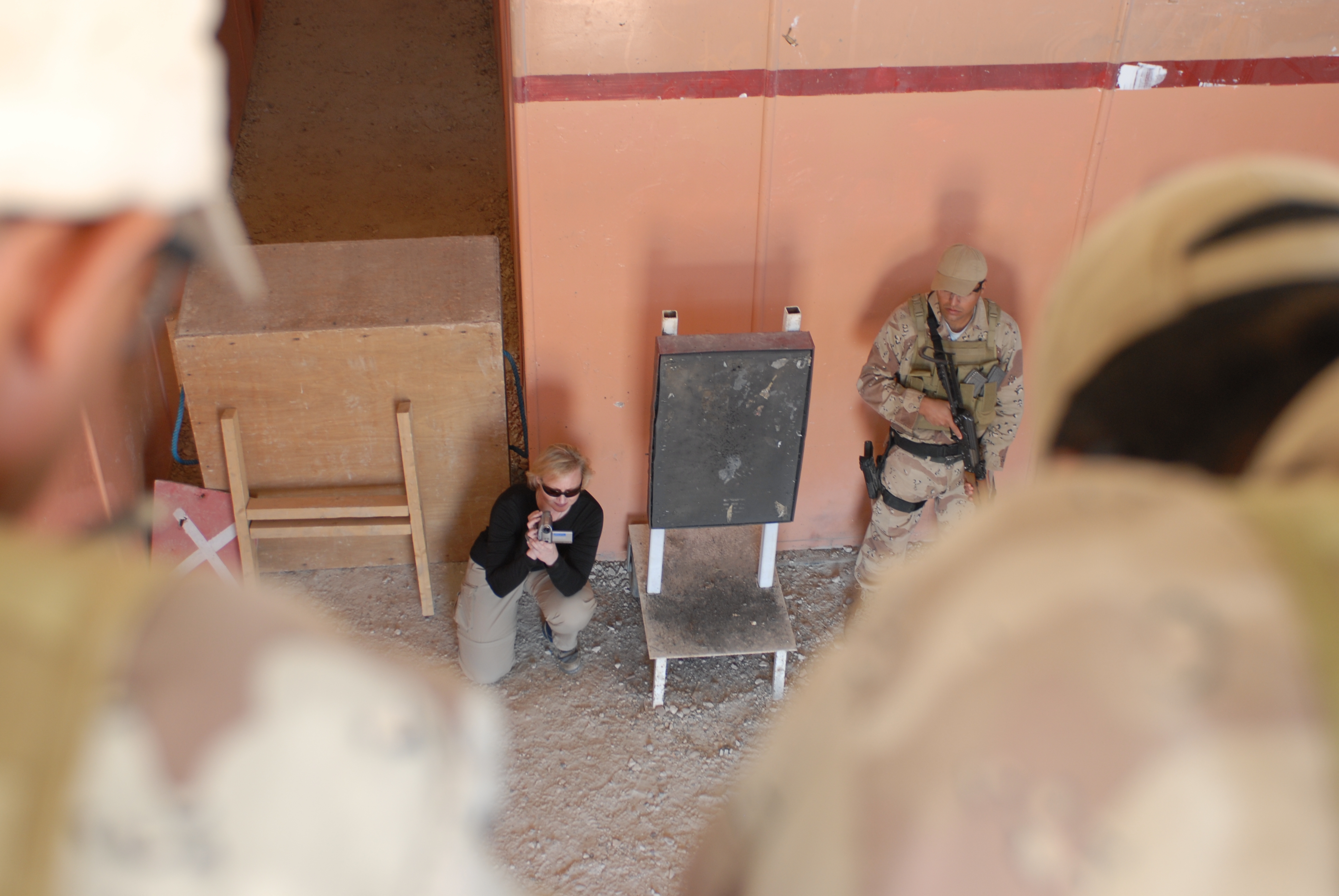 War Reporter Alex Quade shooting video in Iraqi shoot-house used for live fire training. Iraq 2008.