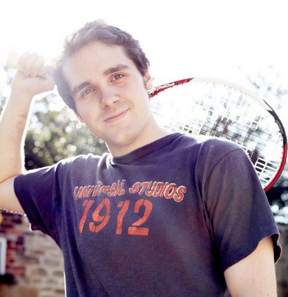 Inexplicably posing with a tennis racquet.