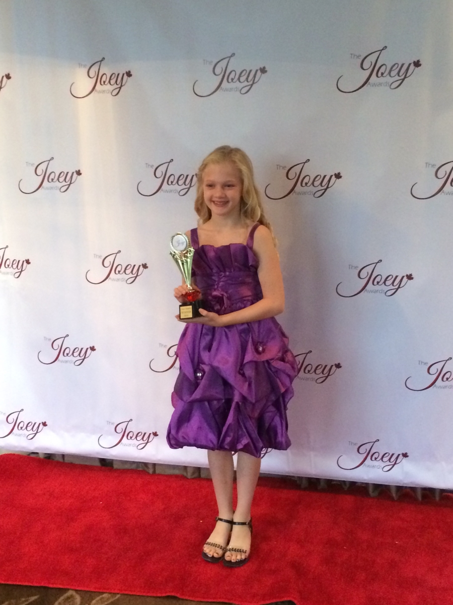 All Smiles on the Red carpet with her Joey Award. Smiling for the Press.
