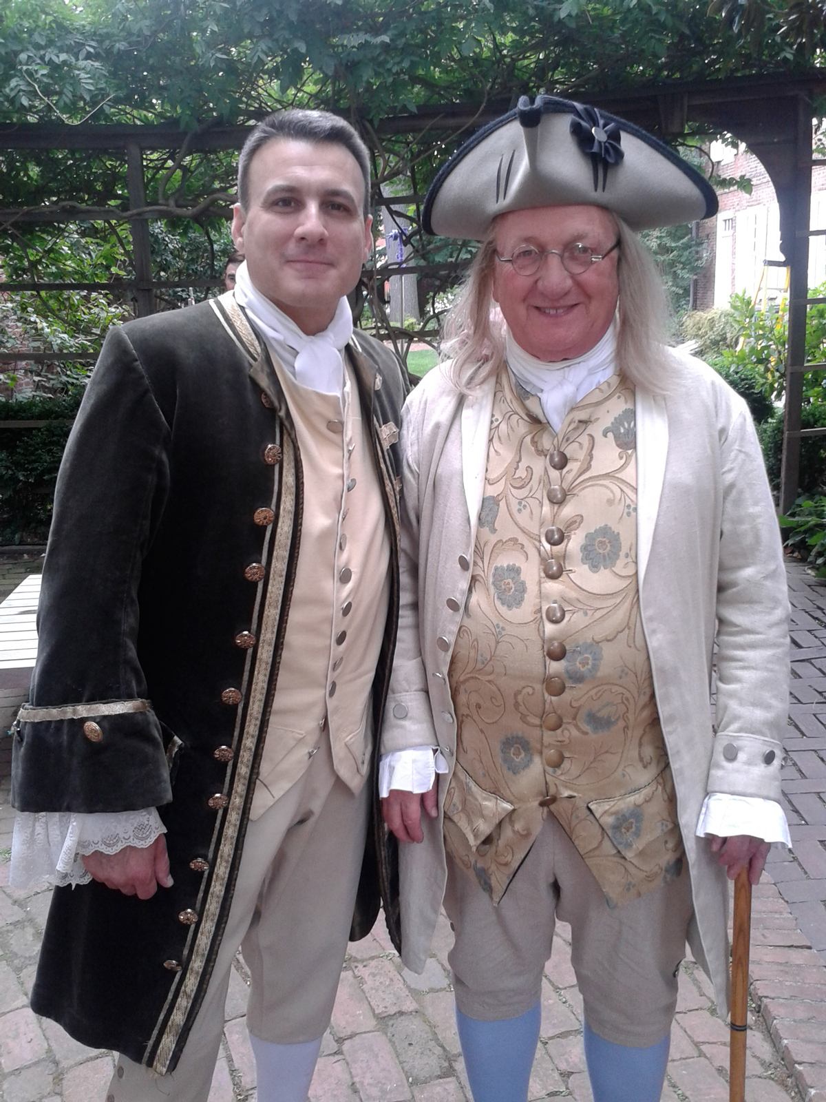 Noel Ramos portrays a Colonial Delegate, posing with Ben Franklin as they attend a meeting.