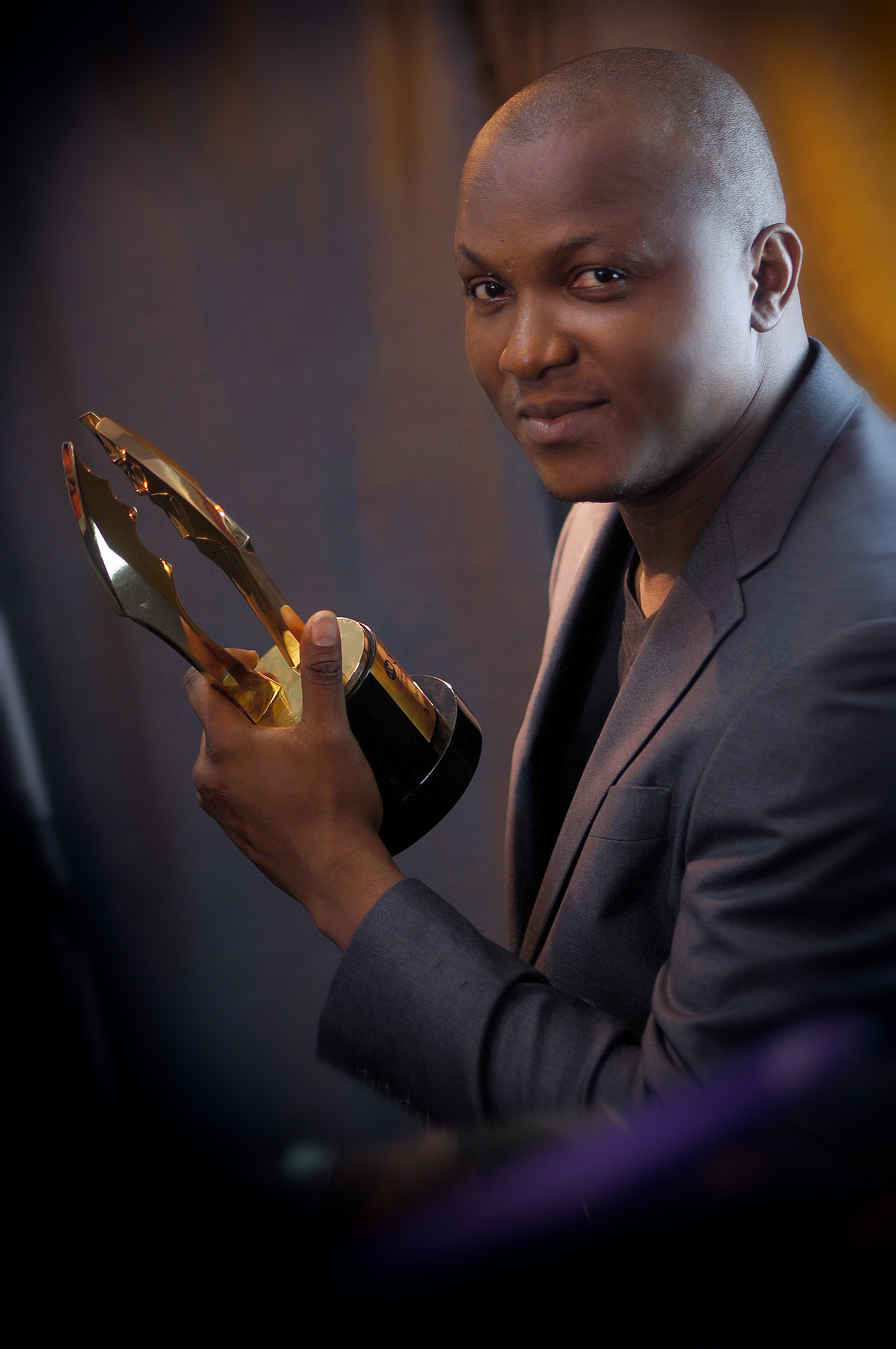 Stanlee Ohikhuare holding up the Award won at the 2014 AMVCA for the DEADWOOD Docu-drama