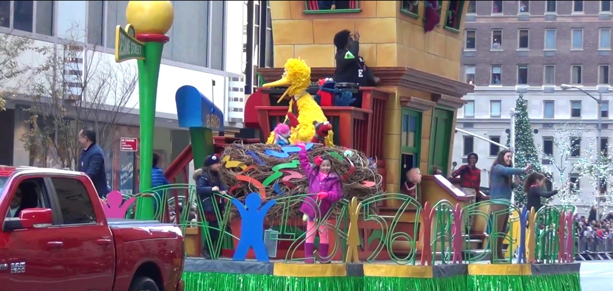 RAINA CHENG on the Sesame Street Float waves to spectators at the 89th Macy's Thanksgiving Day Parade, 11/26/2015