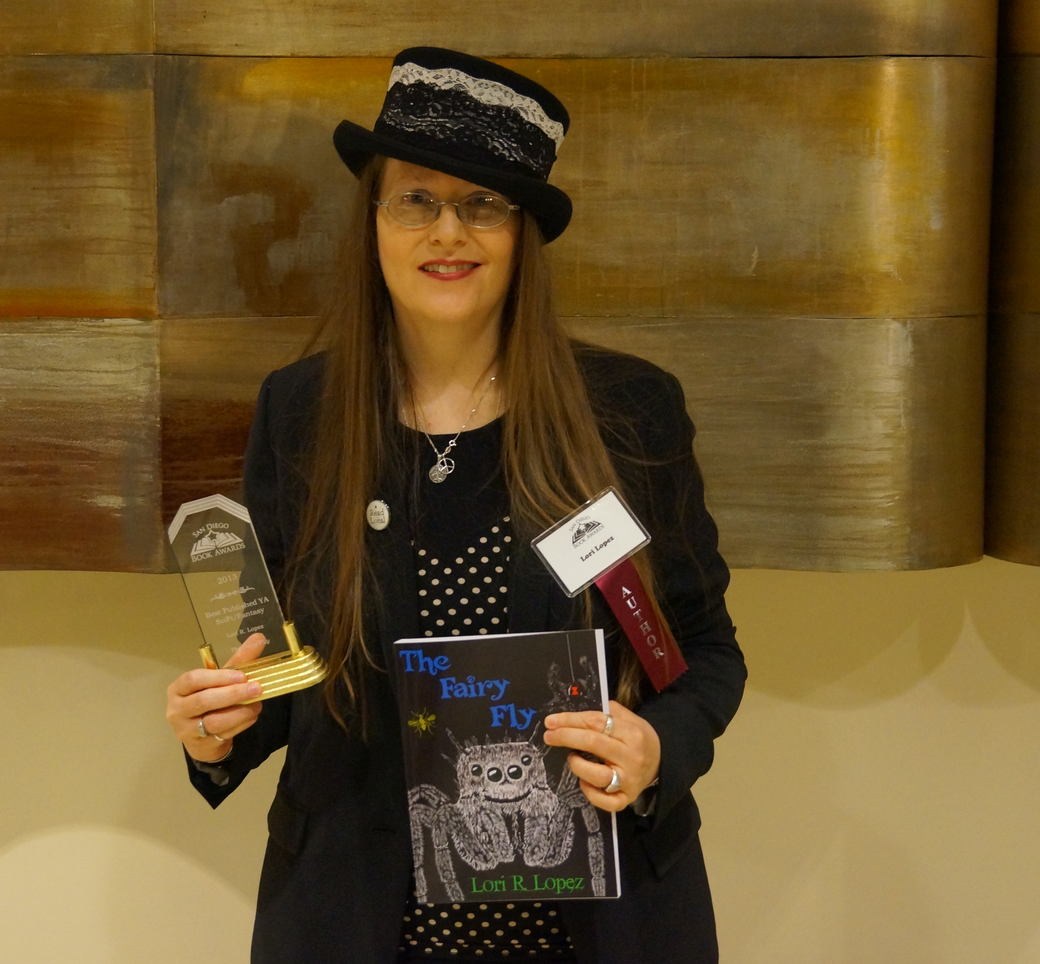 Lori R. Lopez with one of the awards she has received for her writing: 2014 Best Published YA SciFi/Fantasy for THE FAIRY FLY from the San Diego Book Awards.