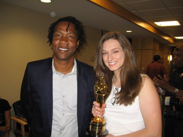 Jasmine Brotzman and Roger Ross Williams share the weight of an Oscar during a leadership seminar lunch at their alma mater