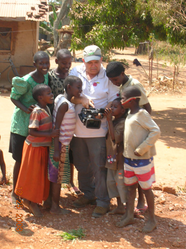 While working on a documentary Dan takes time to show Ugandan kids how his camera works.